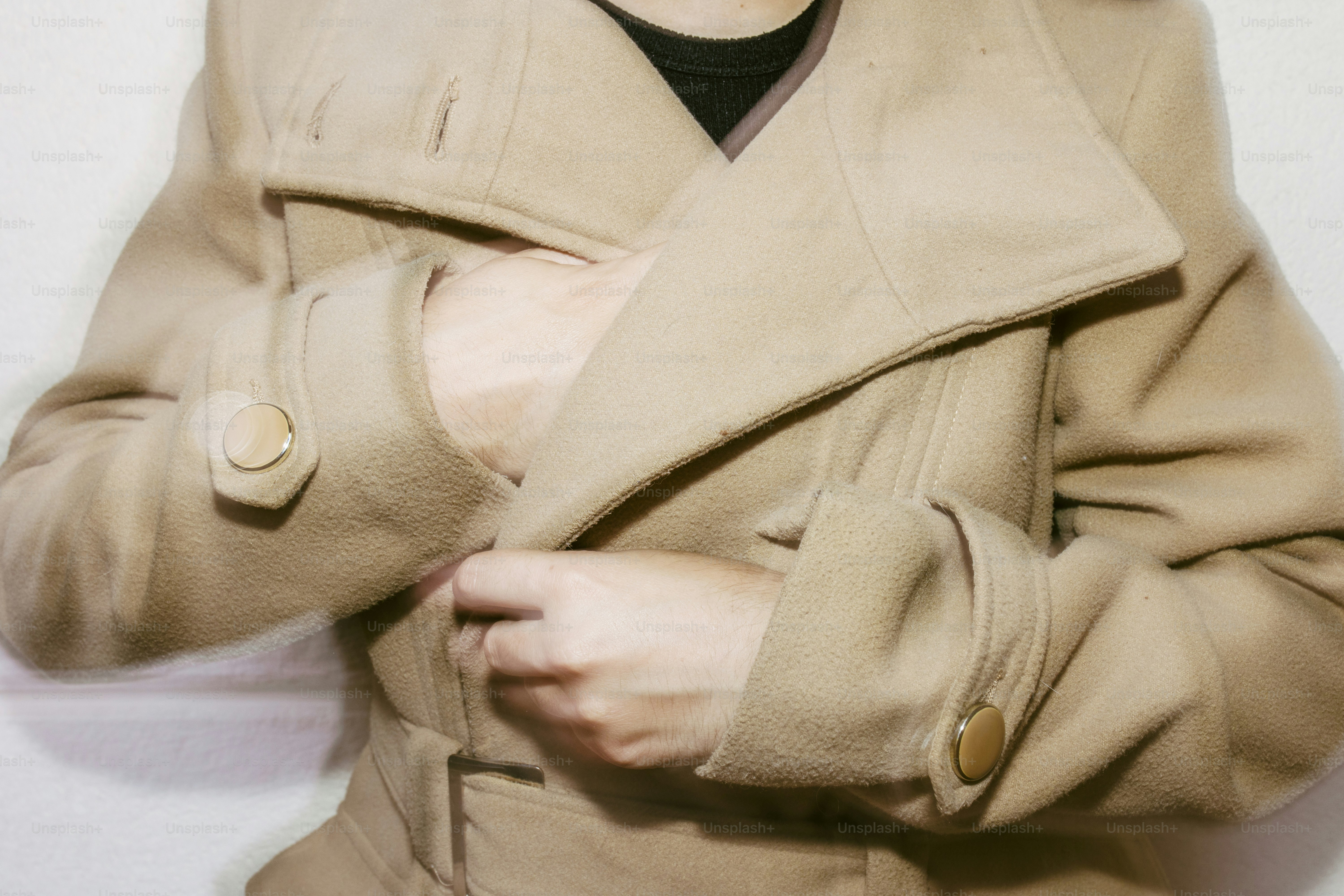 Personne attachant un manteau beige