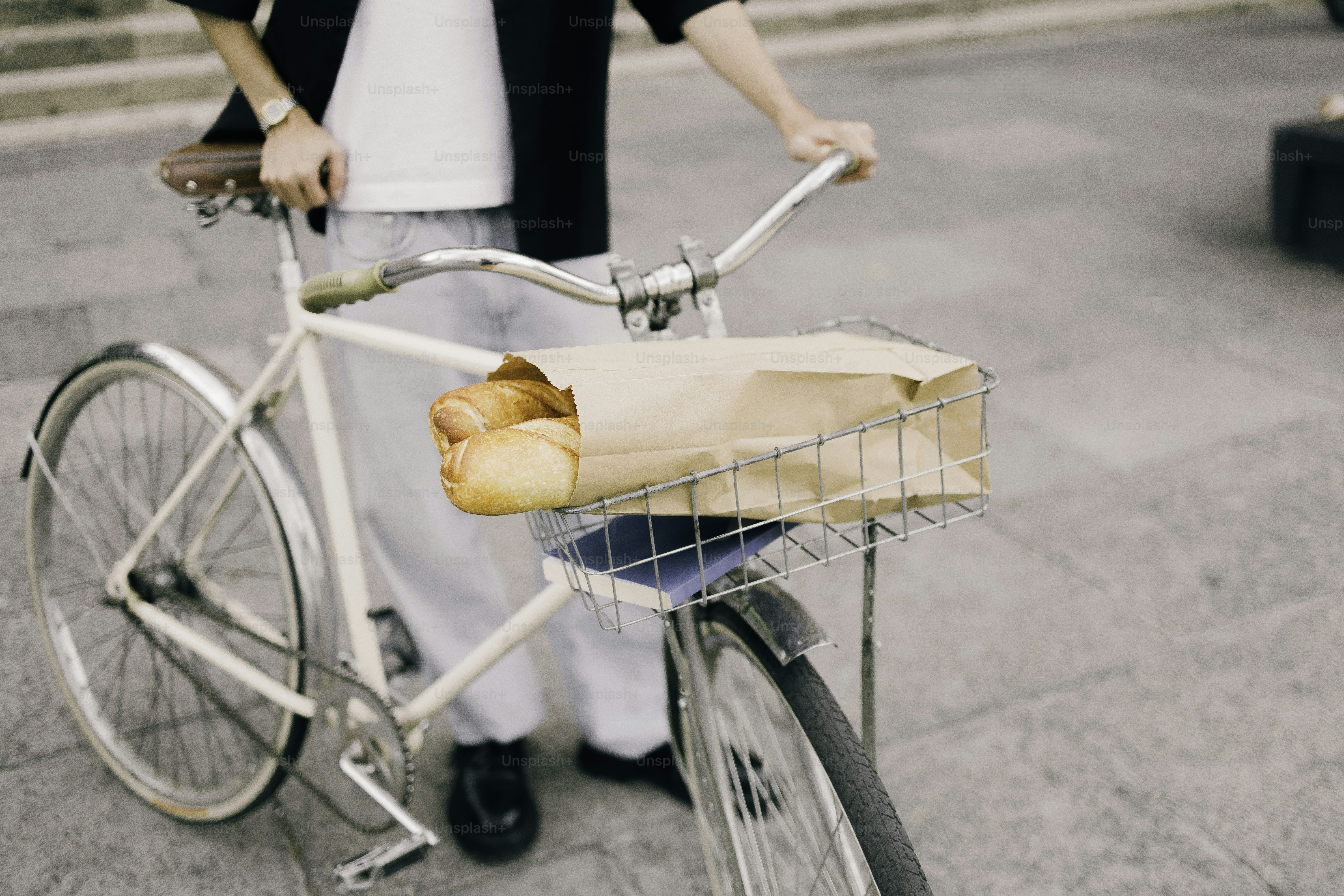 Person with bicycle carrying groceries in basket