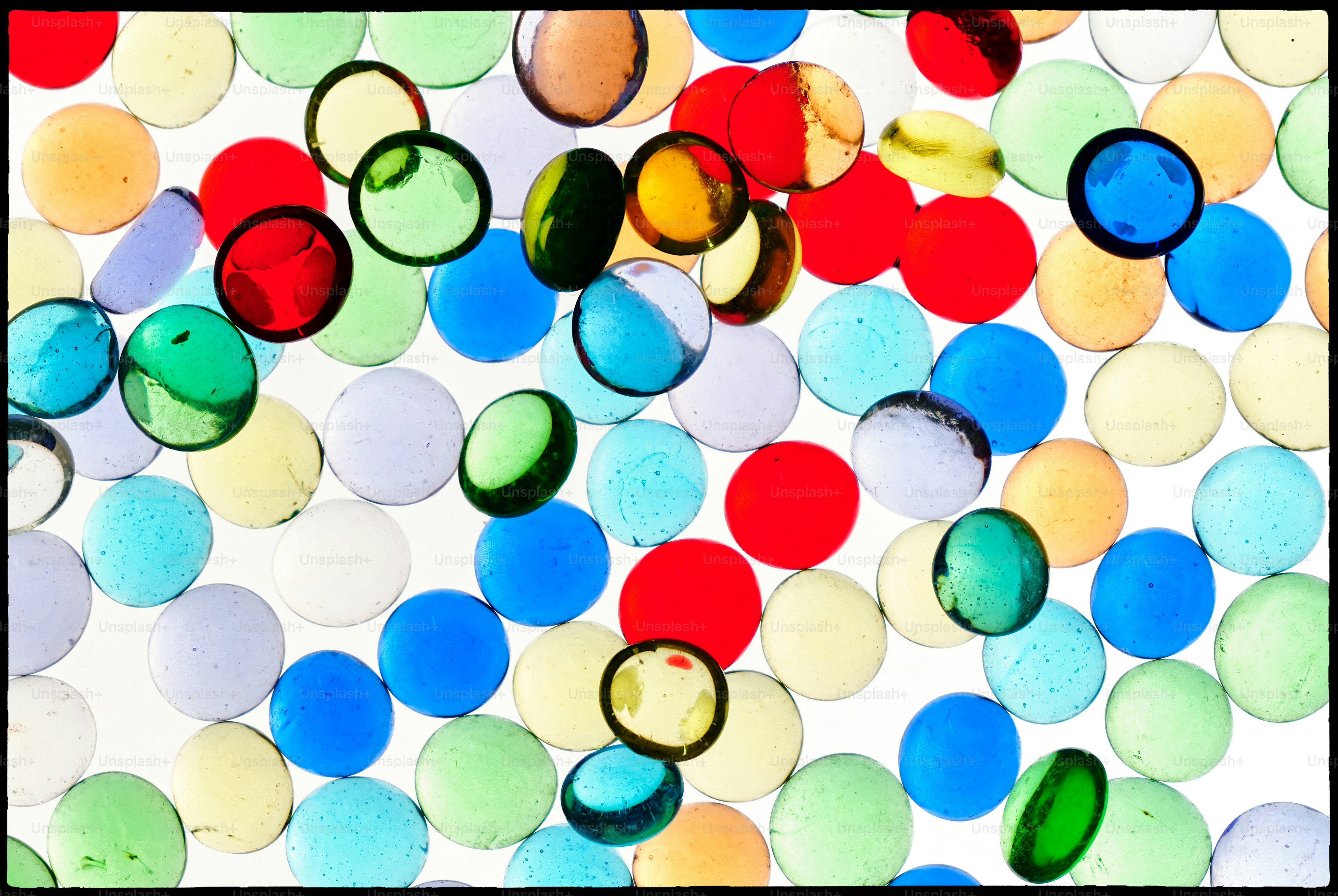 Colorful glass beads scattered on a white surface