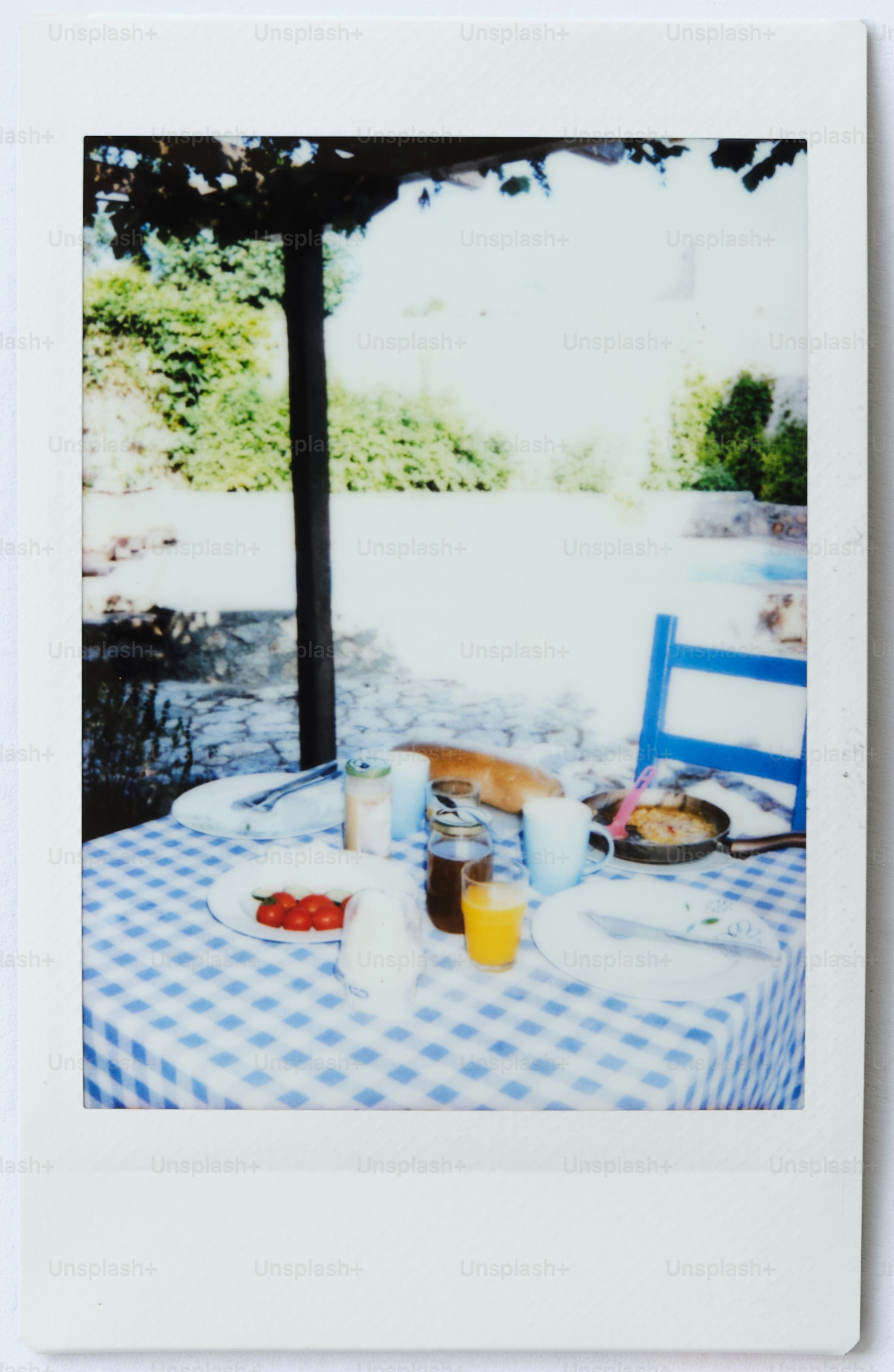 Mesa posta para o café da manhã ao ar livre sob uma pérgula.