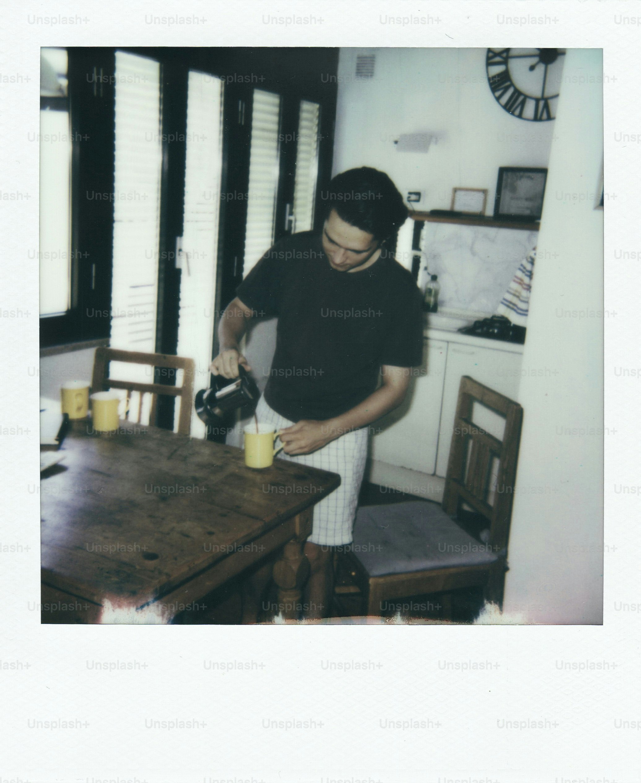 Man pouring coffee into a mug at a table