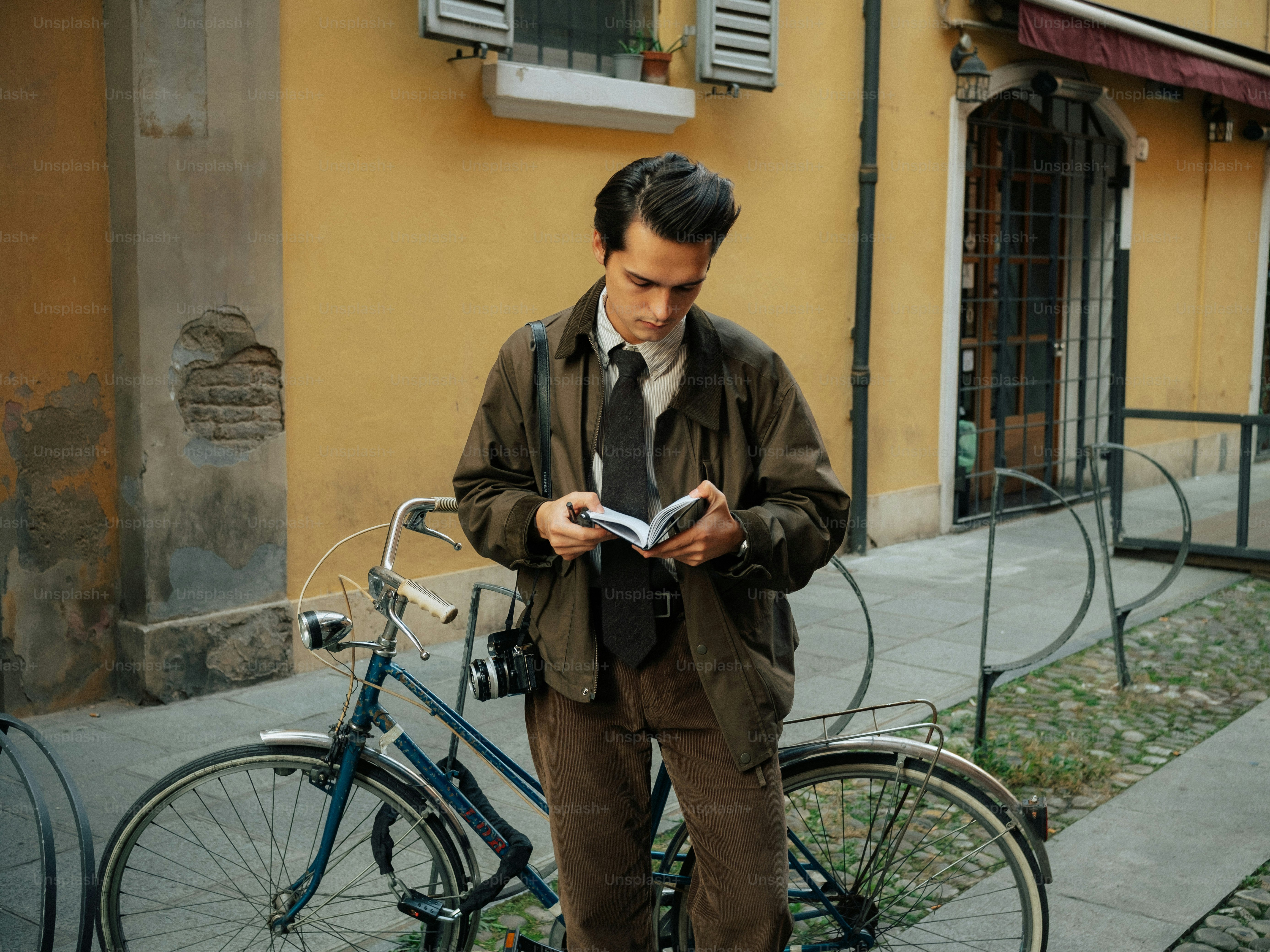 Man in vintage clothes reading a book by a bicycle photo – Education ...
