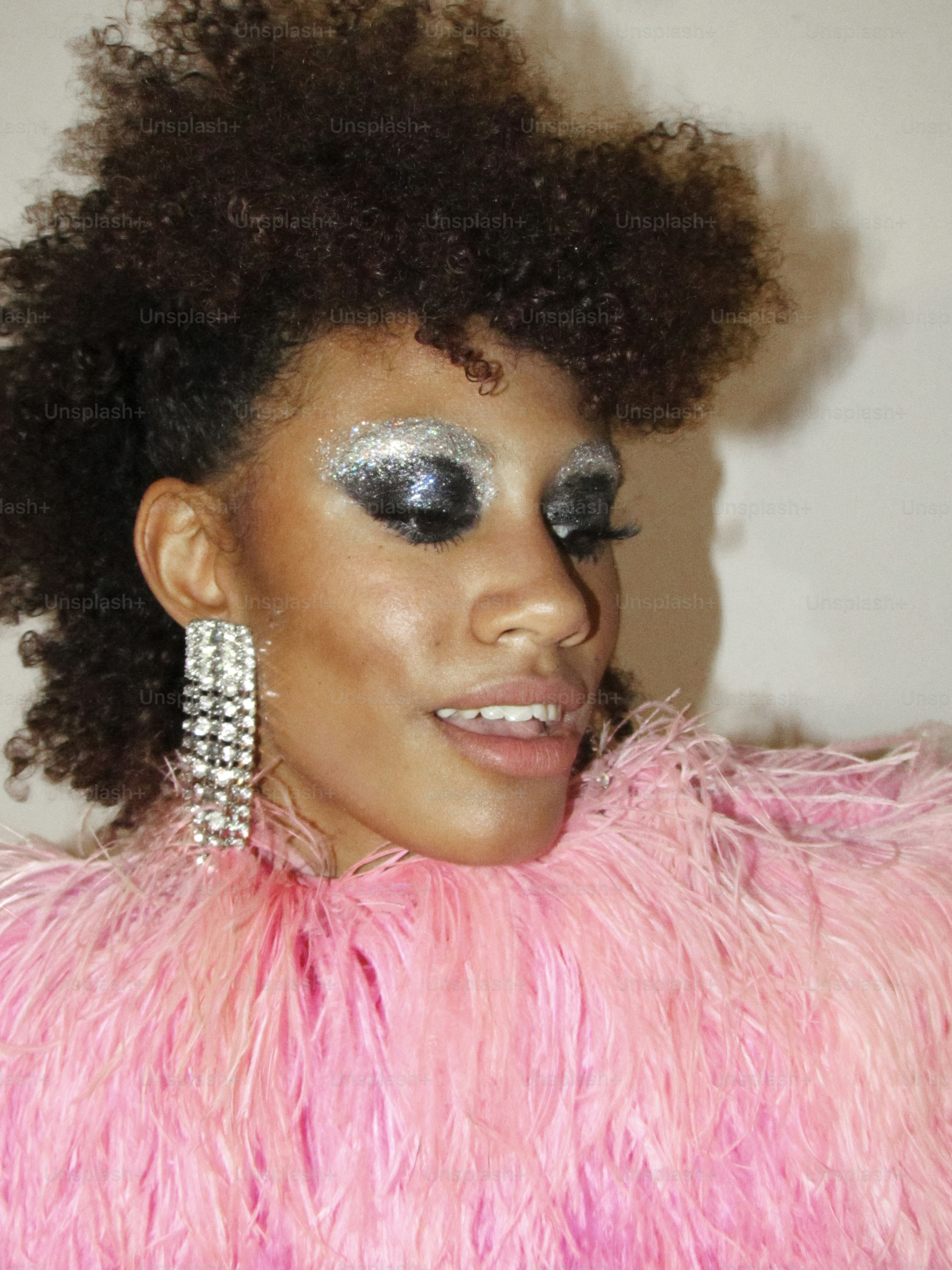 Femme avec fard à paupières pailleté et plumes roses