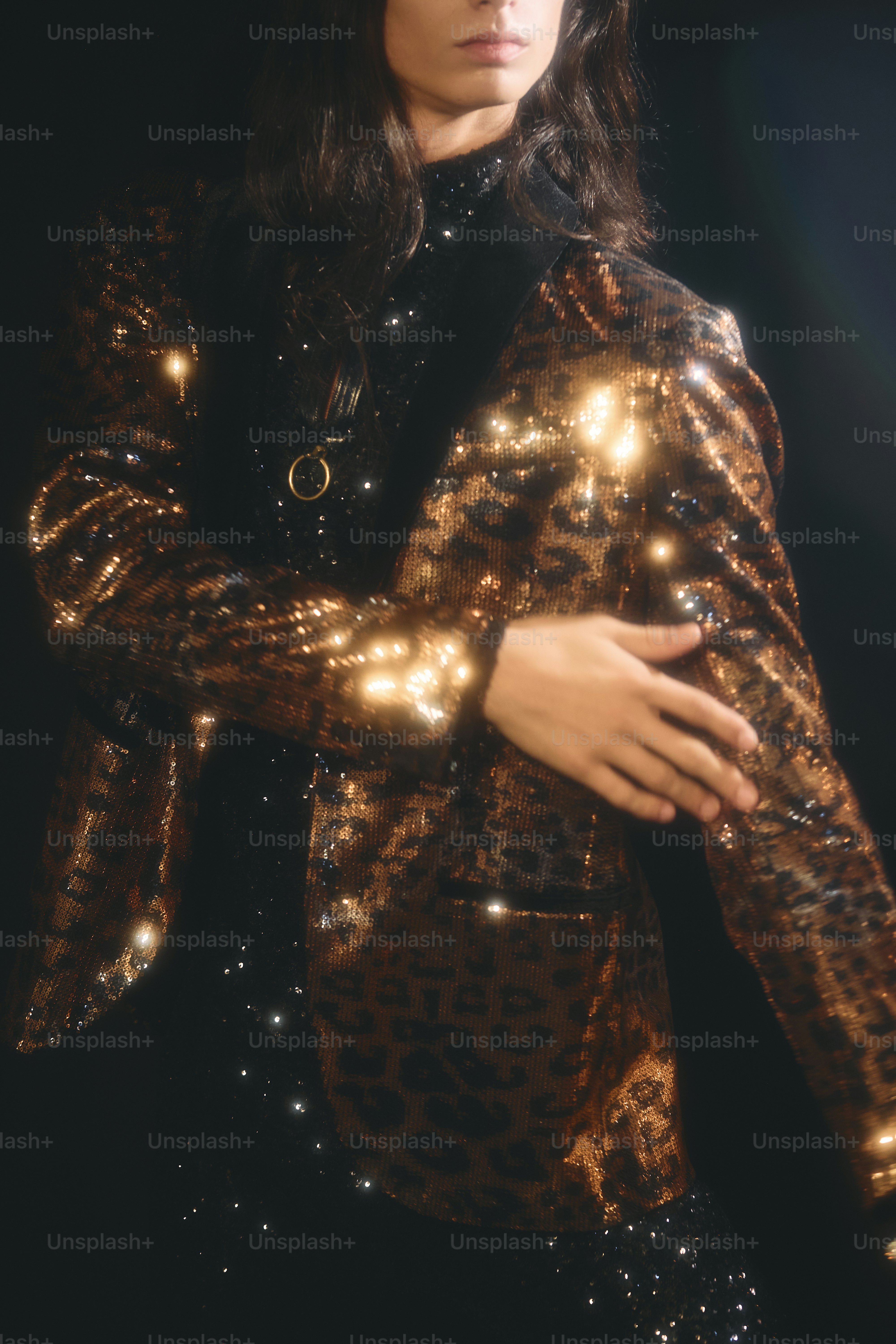 Personne vêtue d’une veste à imprimé léopard scintillante et d’un haut noir.