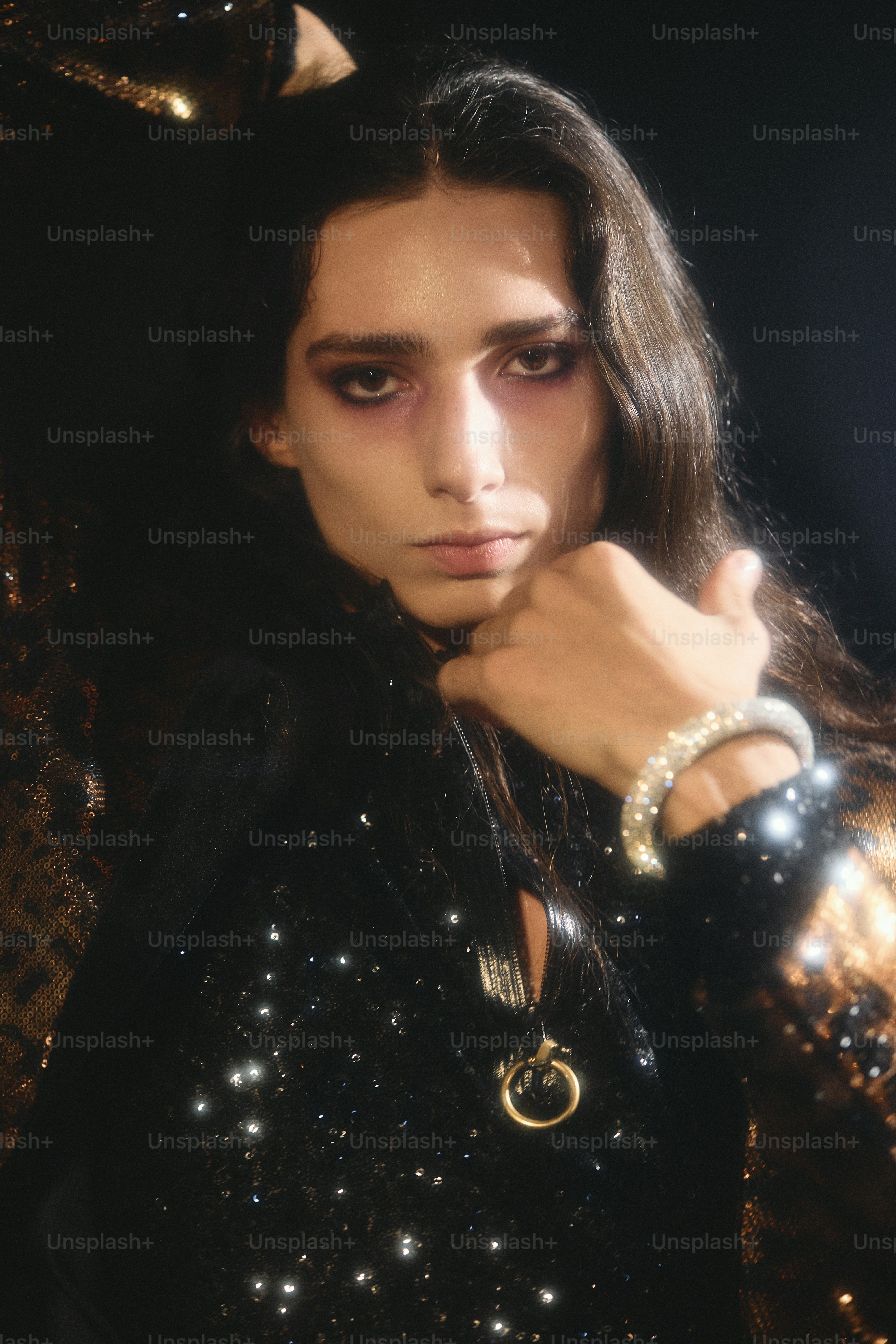 Homme aux longs cheveux noirs et au maquillage dramatique