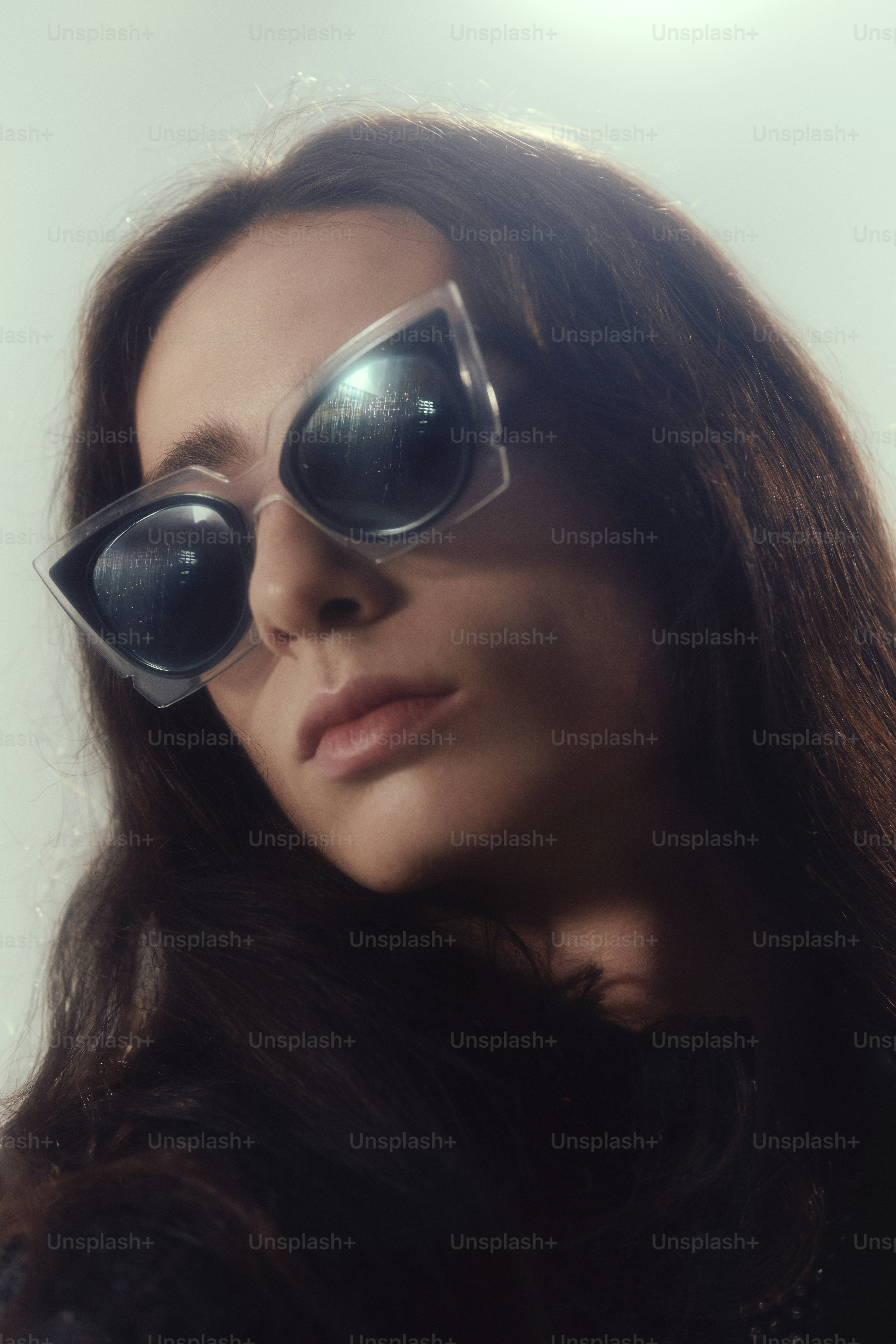 Femme avec des lunettes de soleil élégantes et des cheveux noirs.