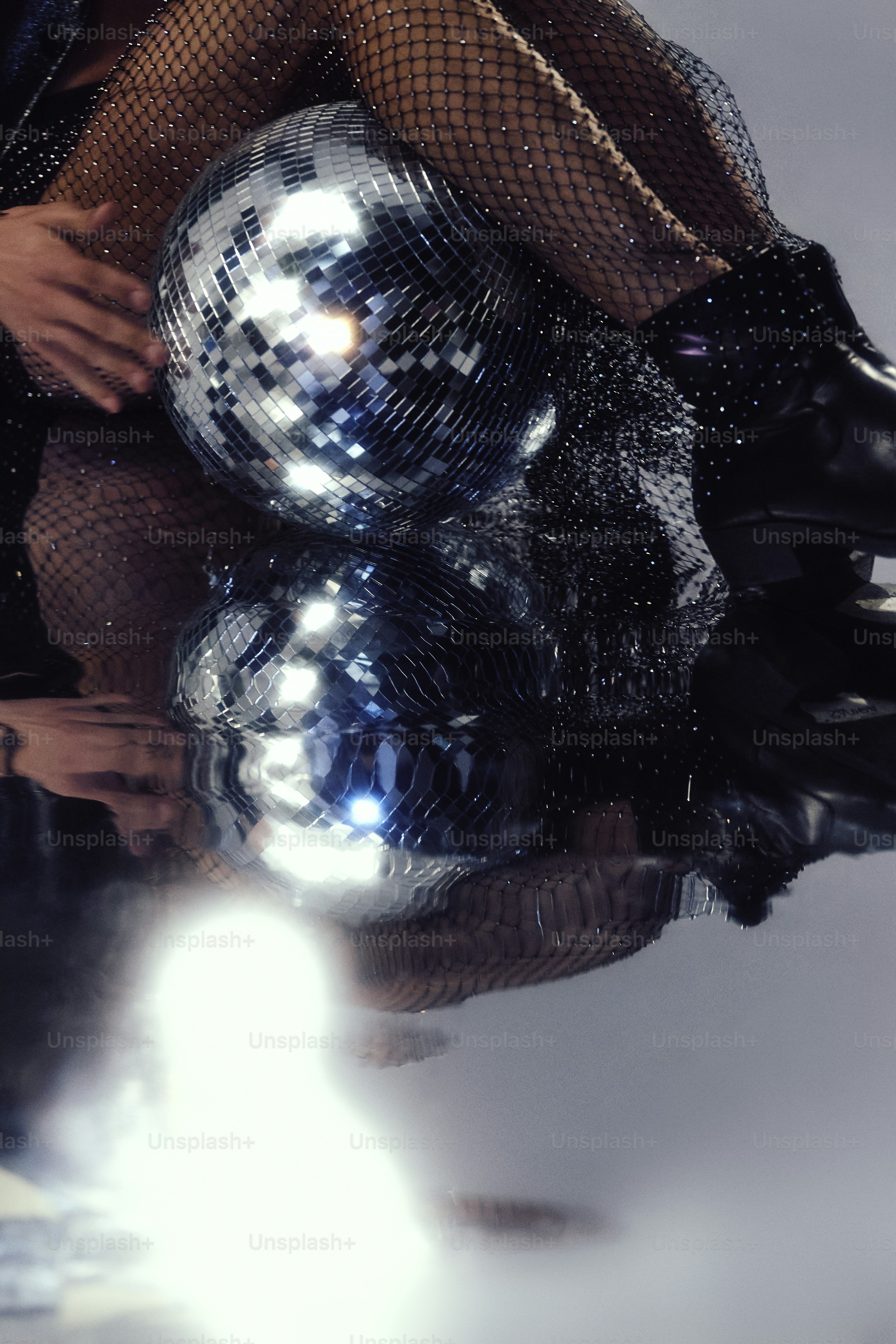 Deux boules disco se reflètent sur une surface humide.