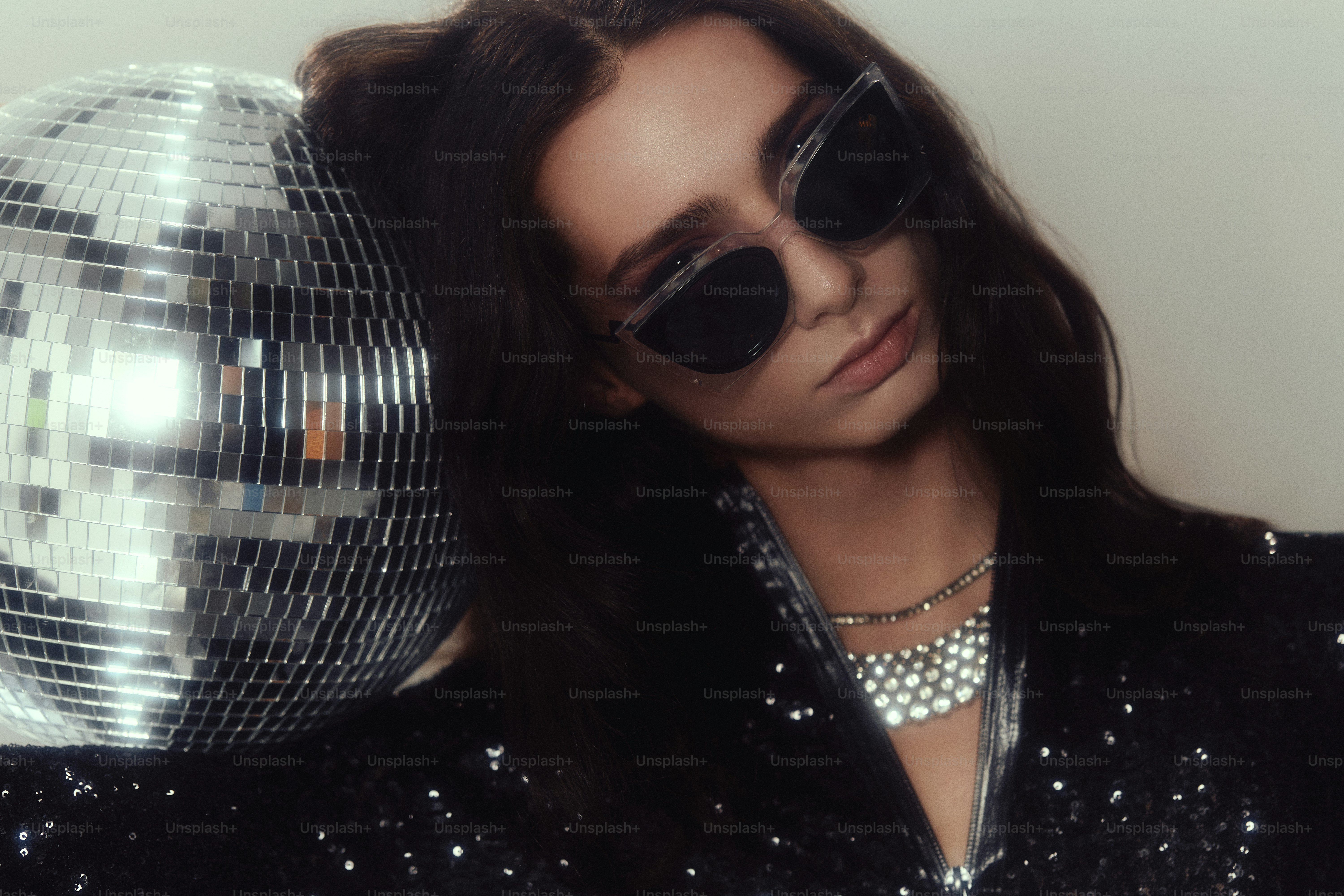 Femme en lunettes de soleil avec boule disco