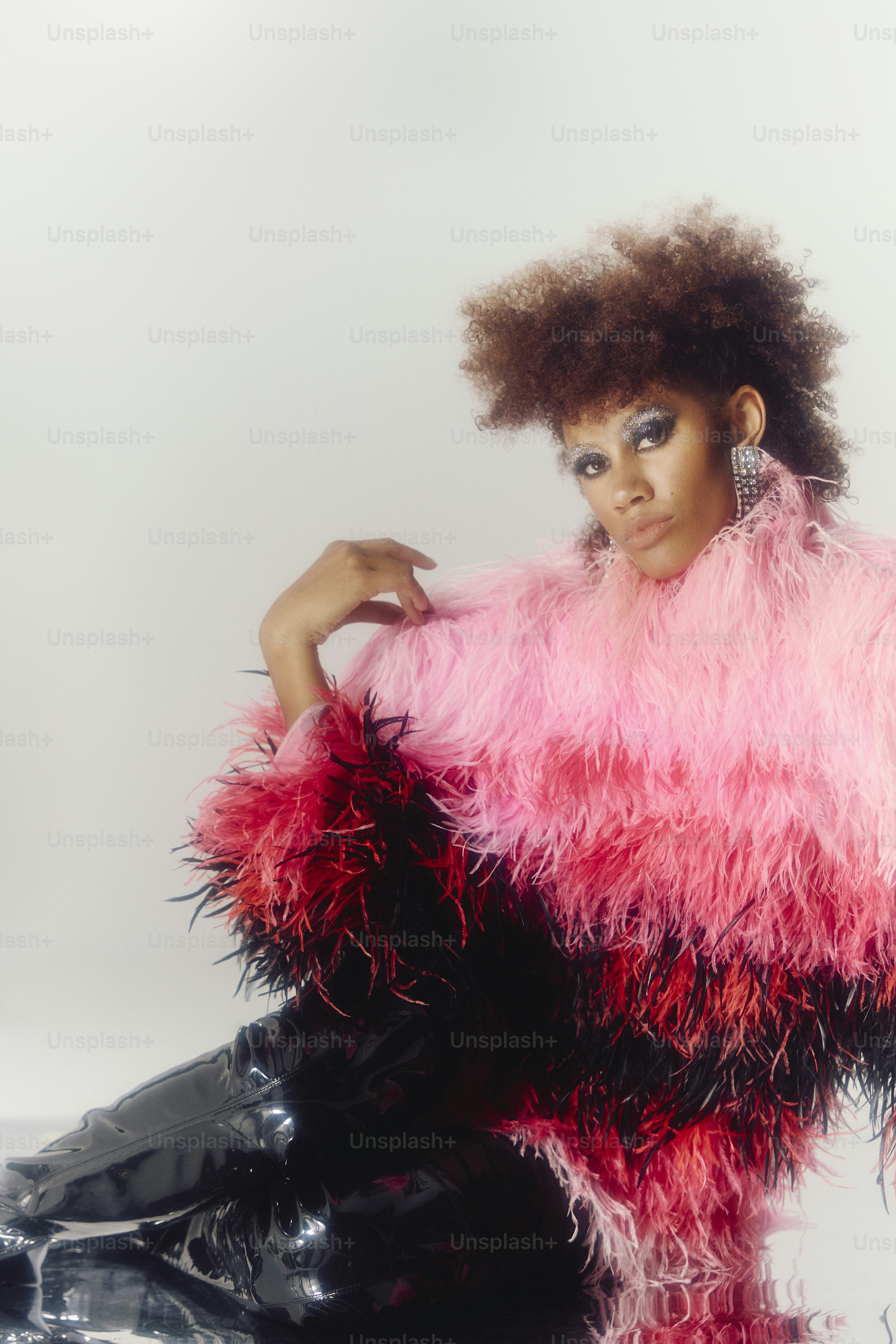 Woman in pink and black feathered jacket and shiny pants