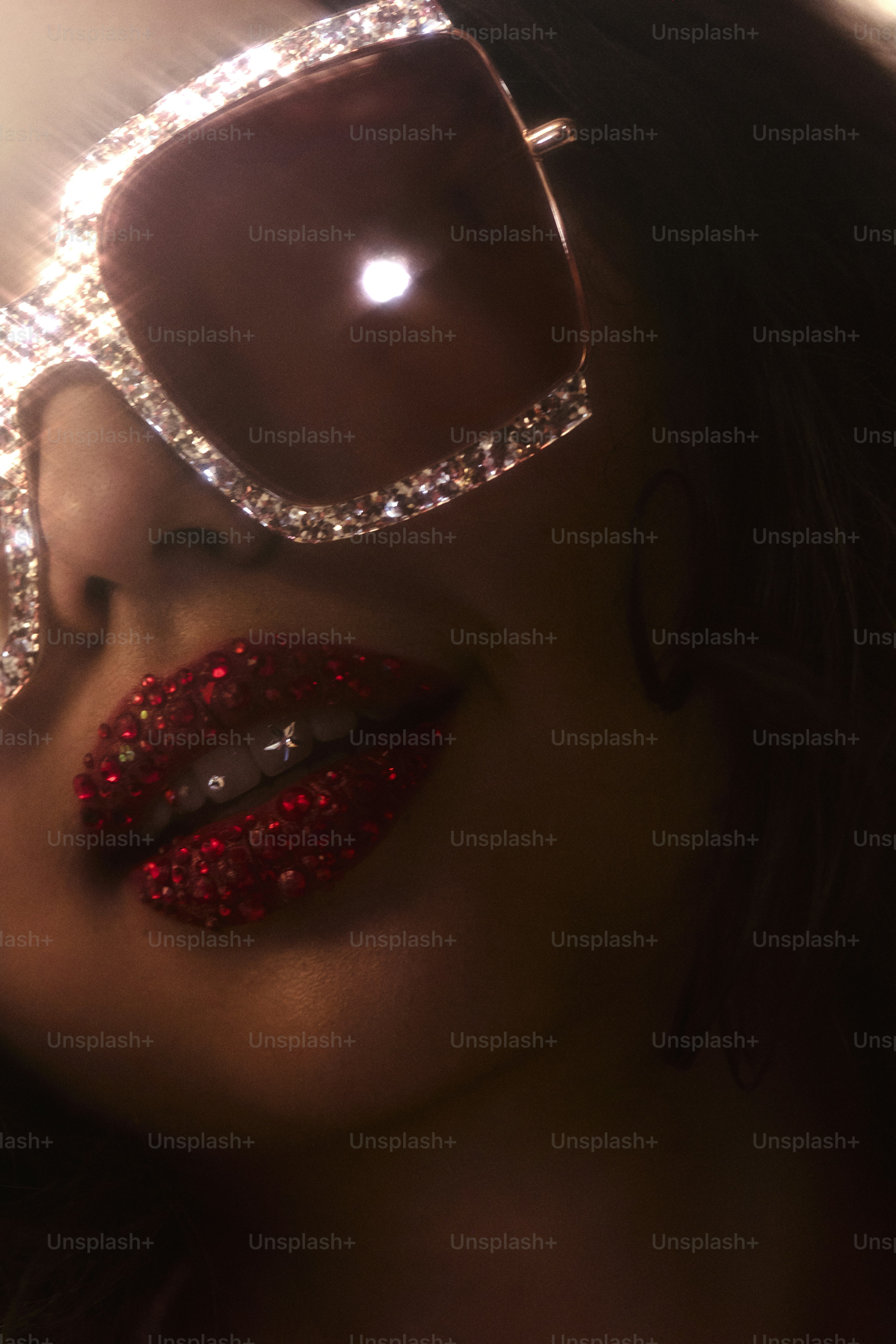 Woman with bejeweled sunglasses and red glitter lips