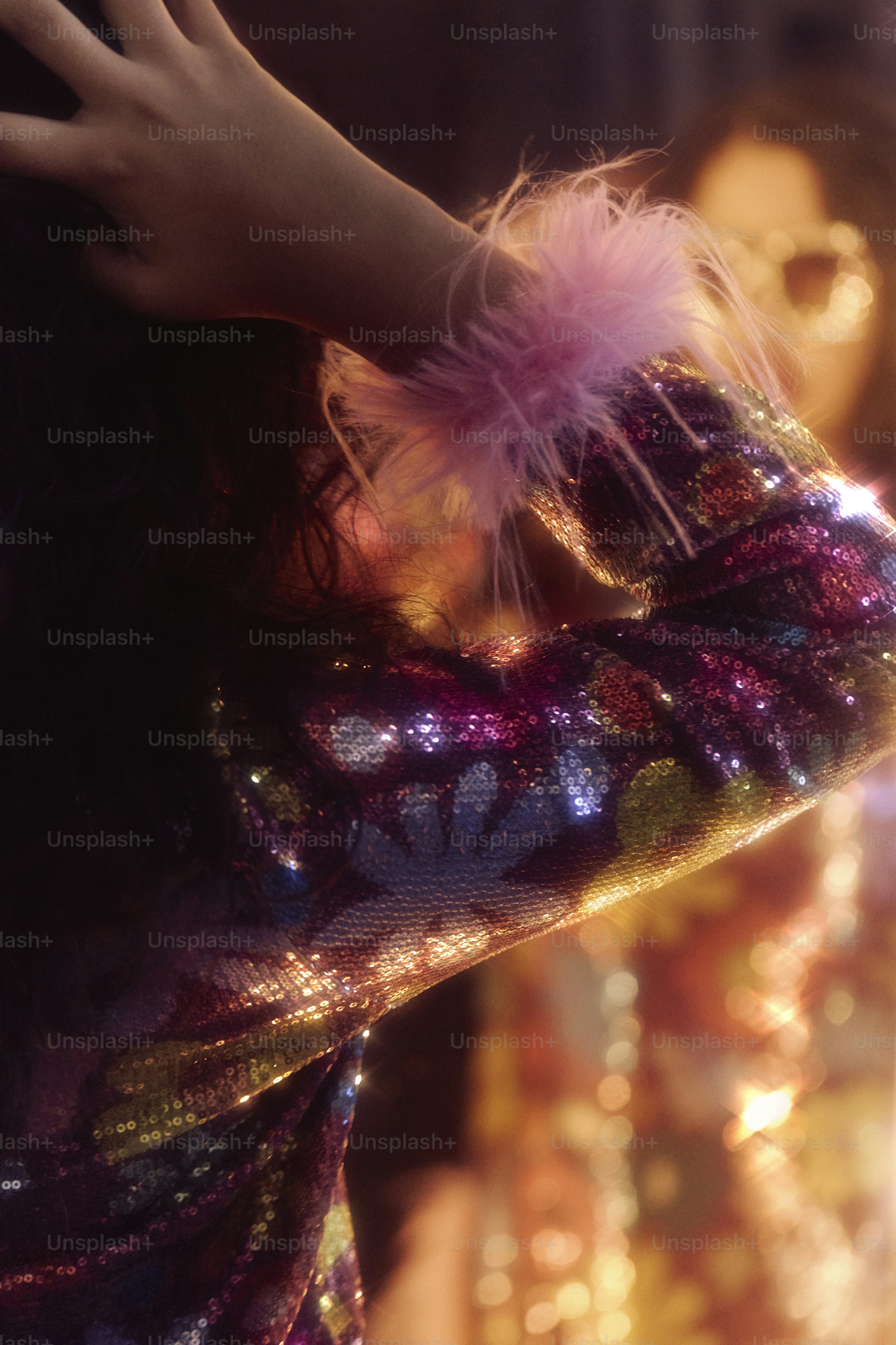 Woman in sparkly sequin jacket with pink feather cuff