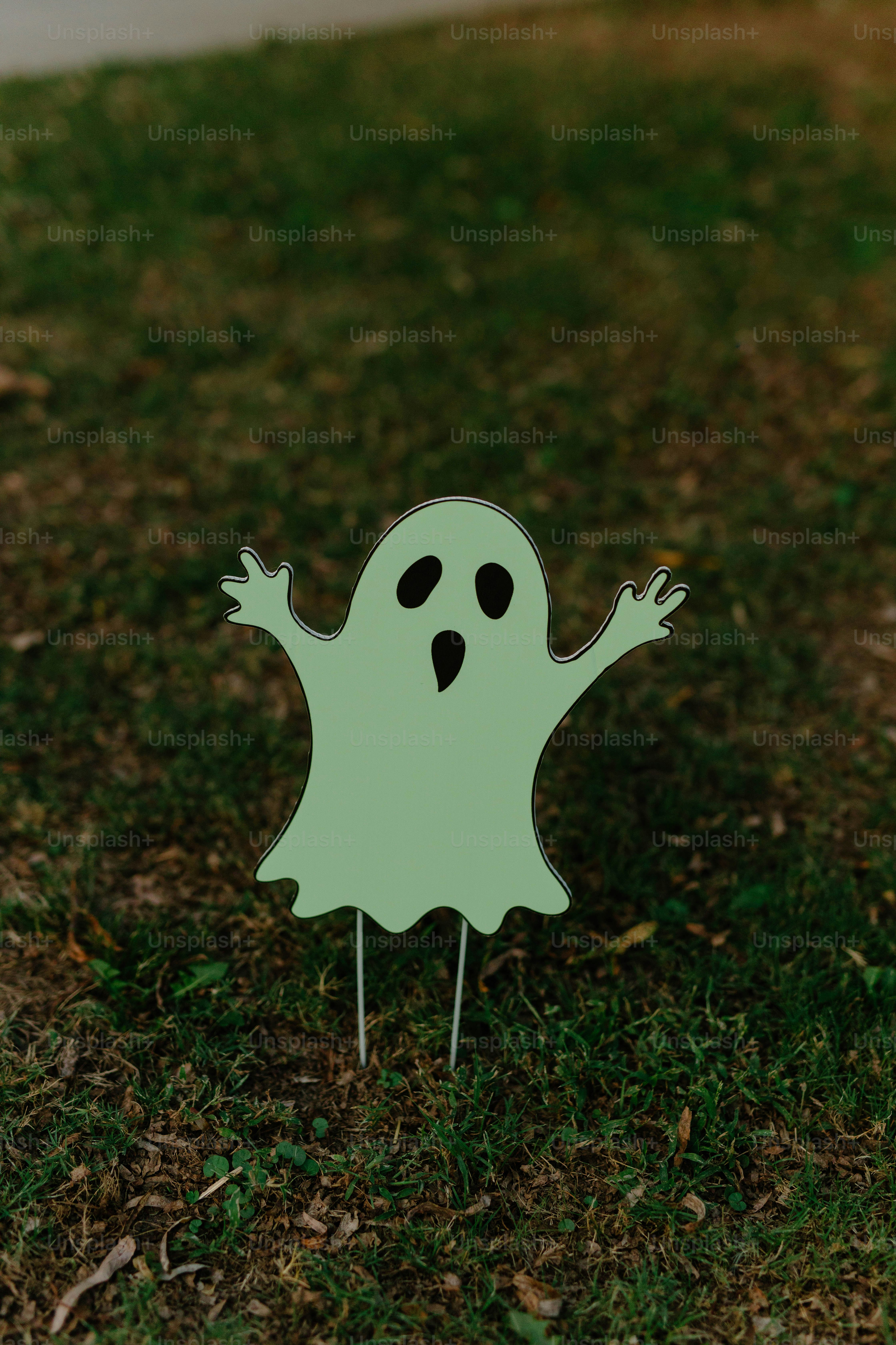 A light green ghost decoration on grass