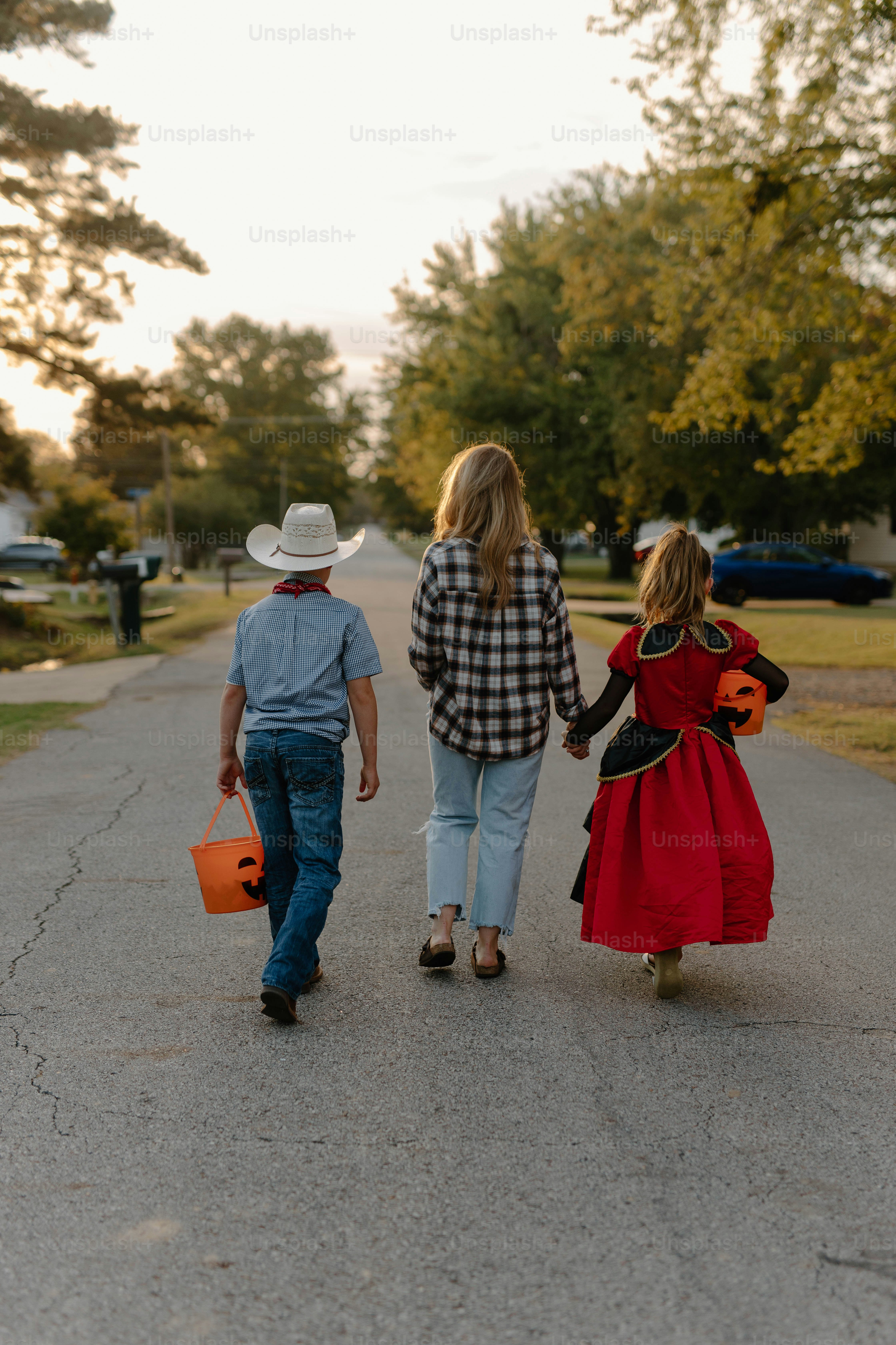 Children in halloween costumes walking down street
