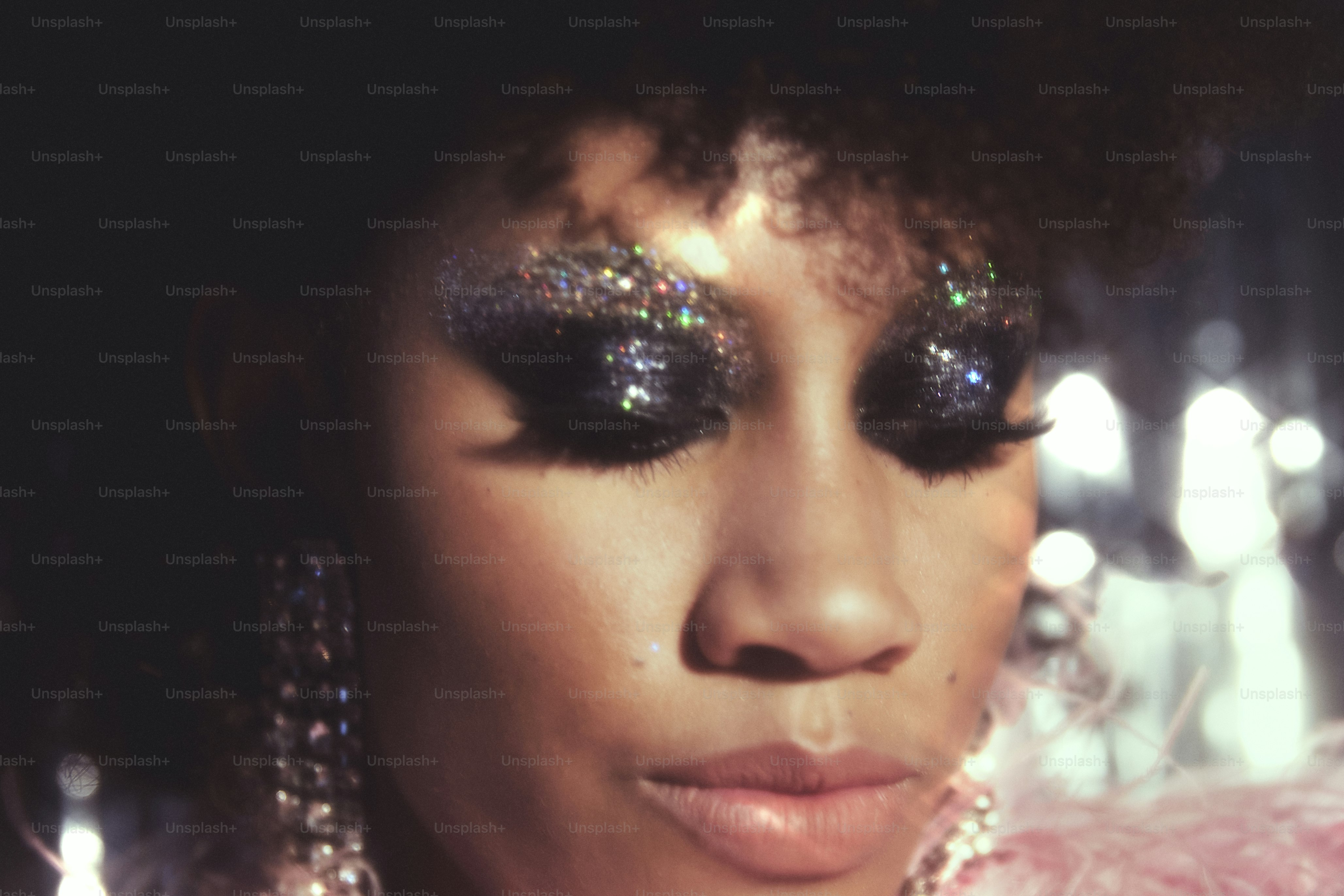 Femme avec fard à paupières pailleté et grandes boucles d’oreilles