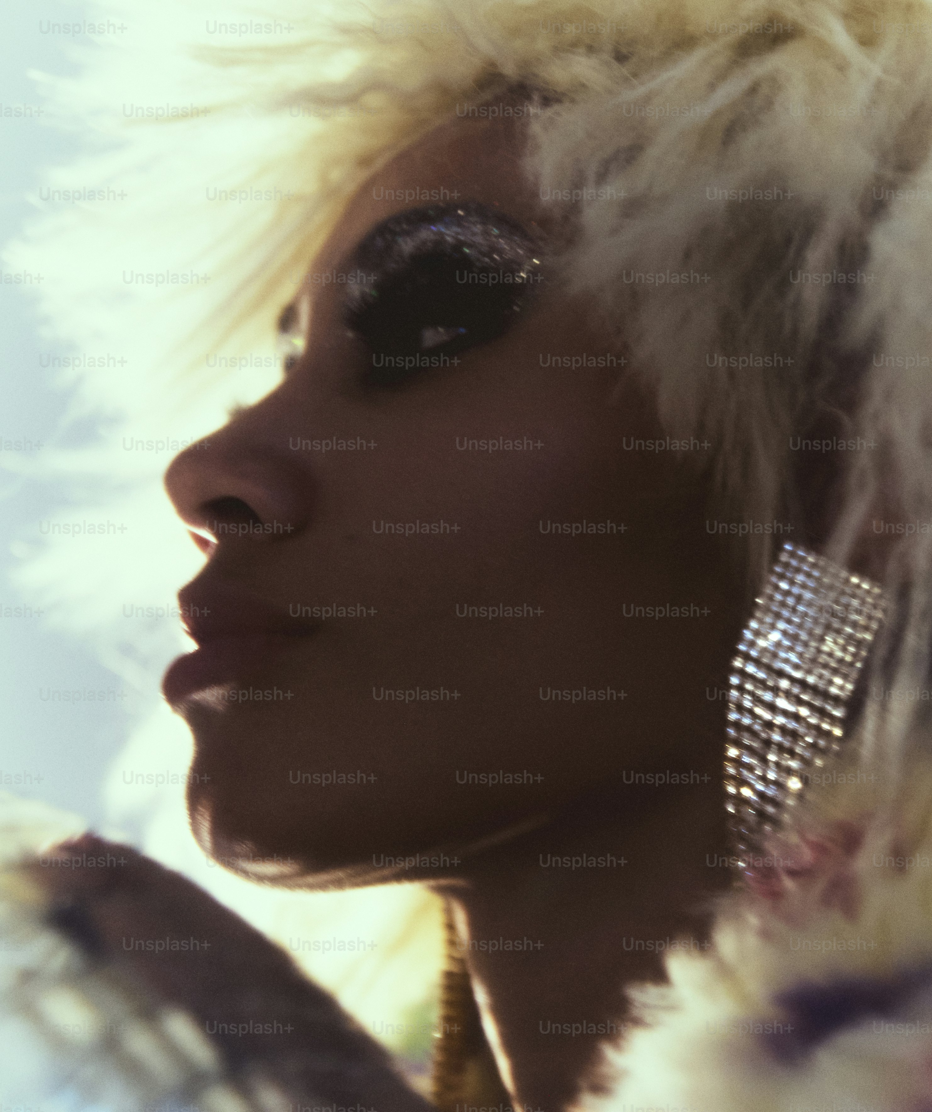 Femme avec fard à paupières pailleté et grandes boucles d’oreilles