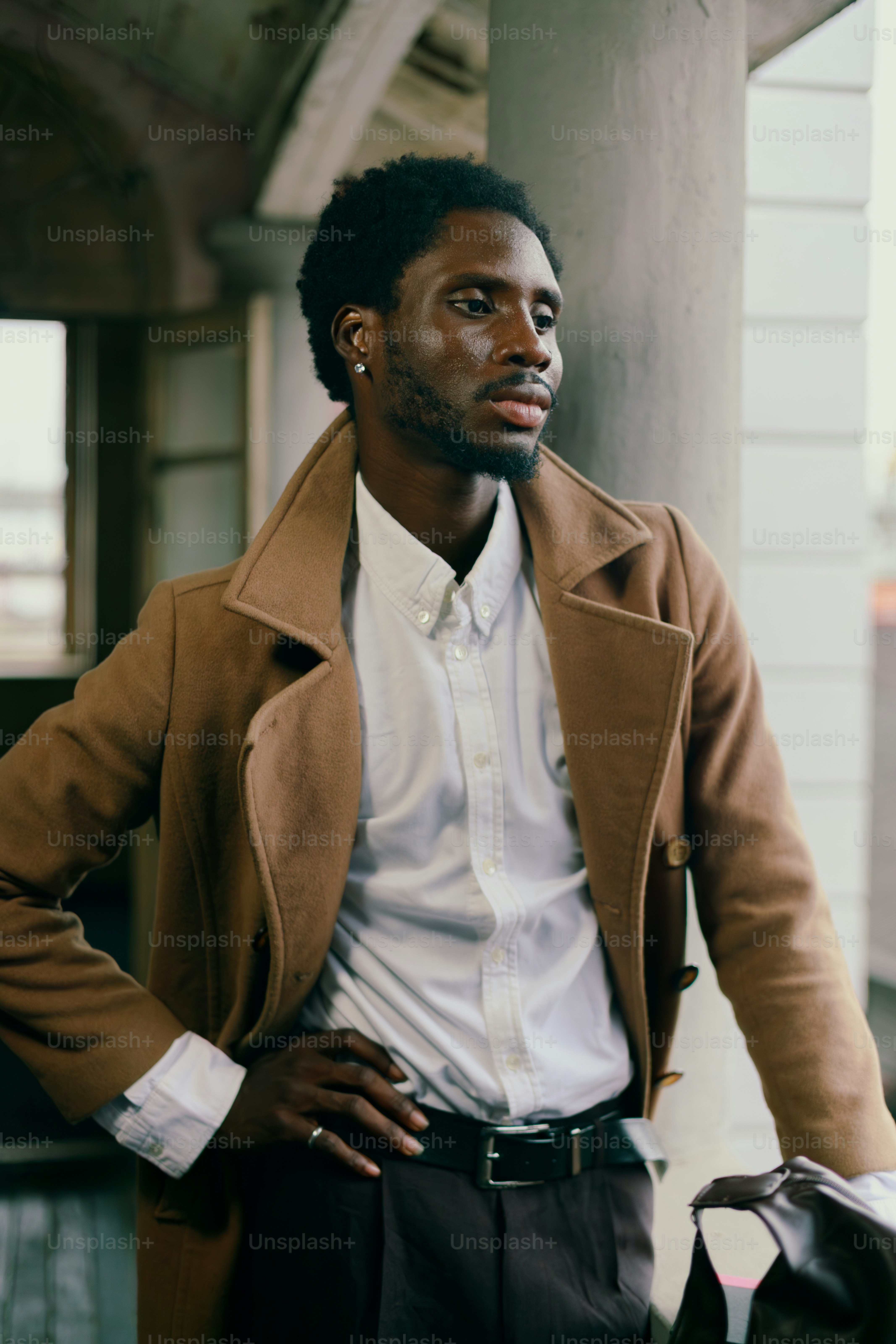 A man in a brown coat and white shirt.