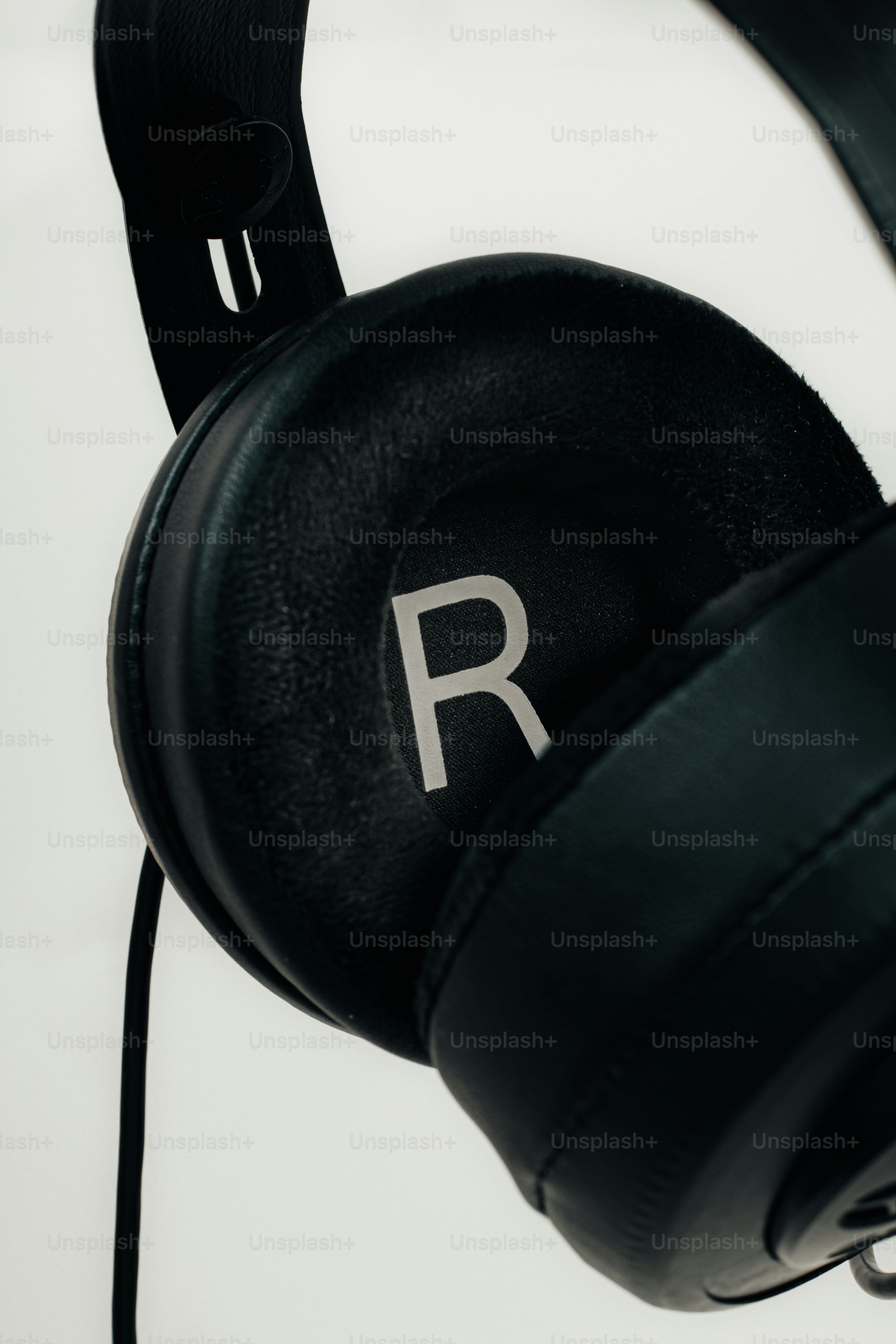 Primer plano de auriculares negros con una marca r.
