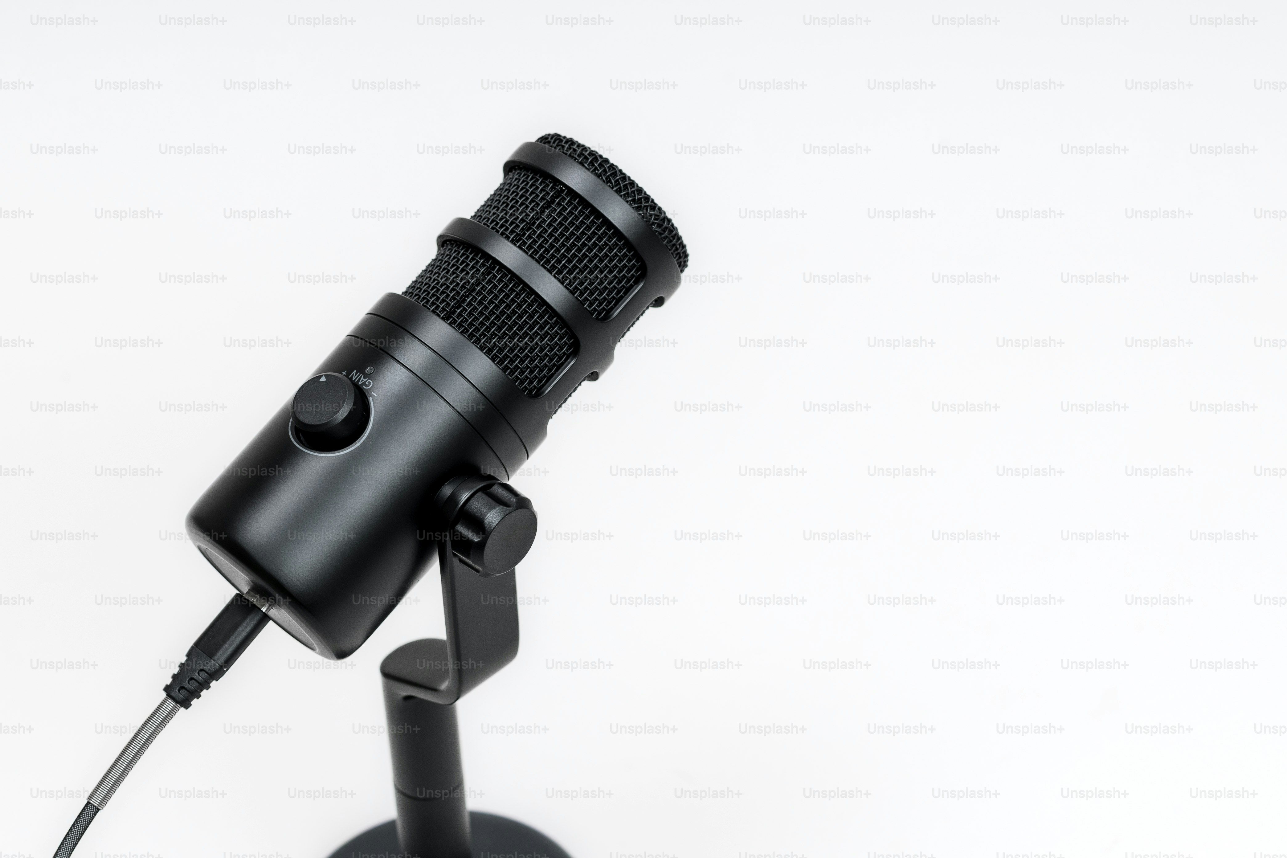 A black microphone on a stand against a white background