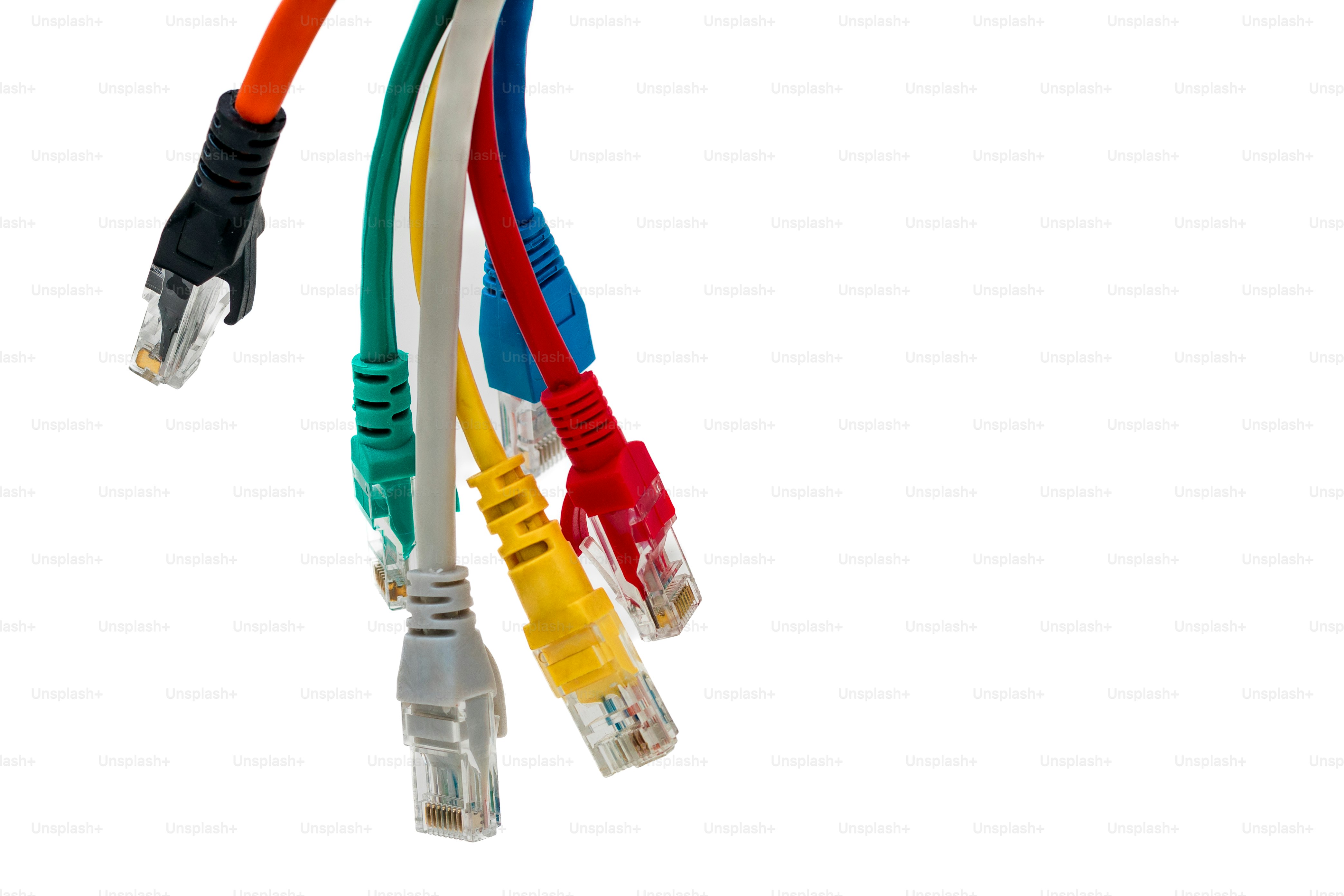 Several colorful ethernet cables hanging against white background