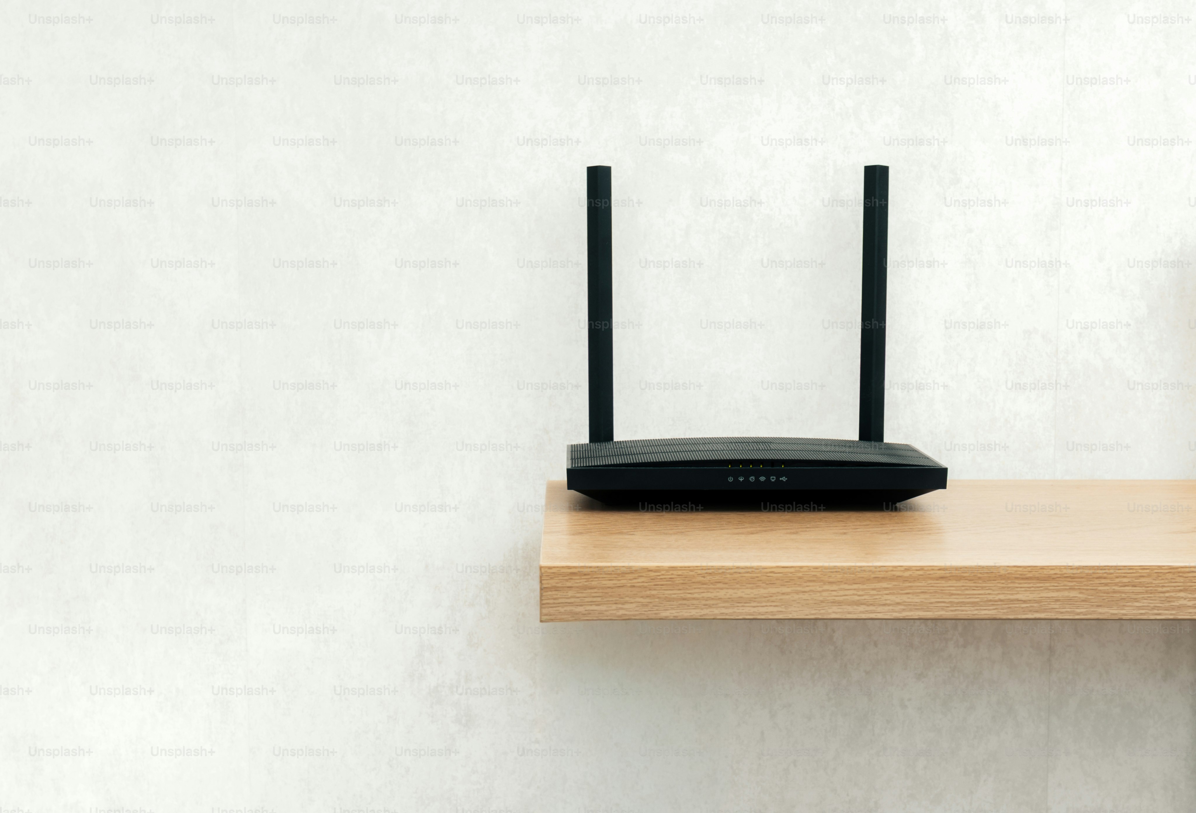 Black wireless router with antennas on shelf