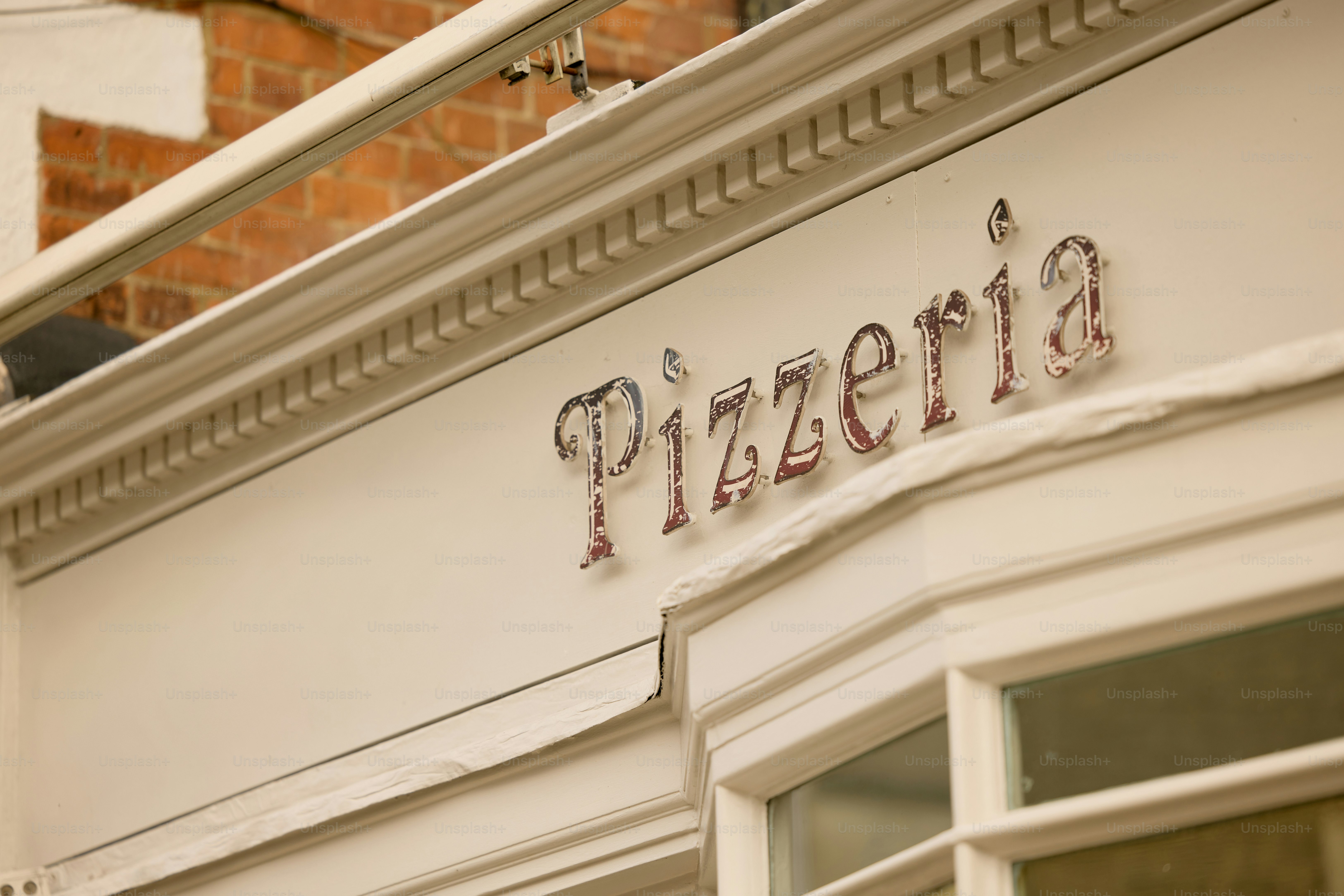 Pizzeria sign on a building facade.