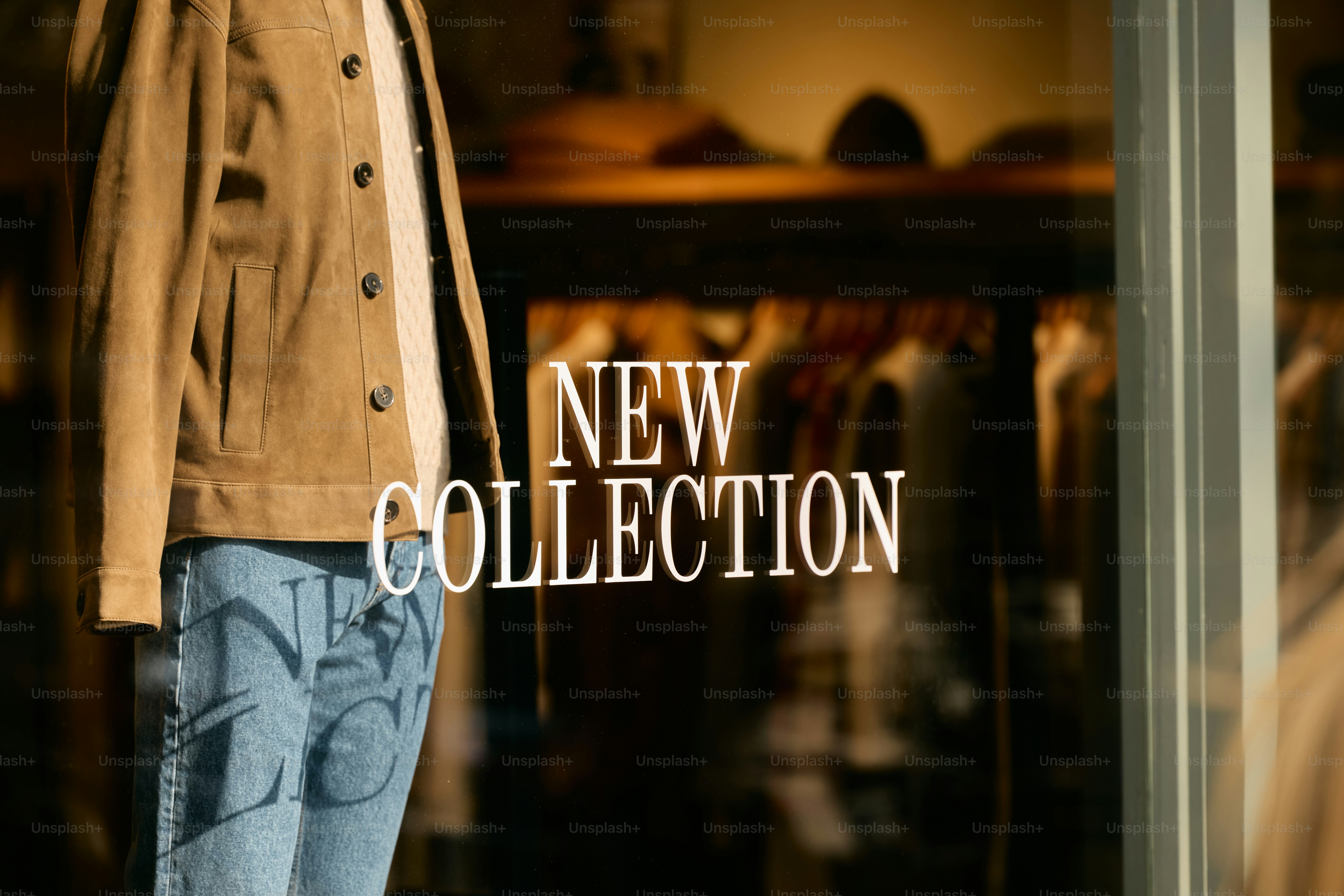 Mannequin in store window with "new collection" text.