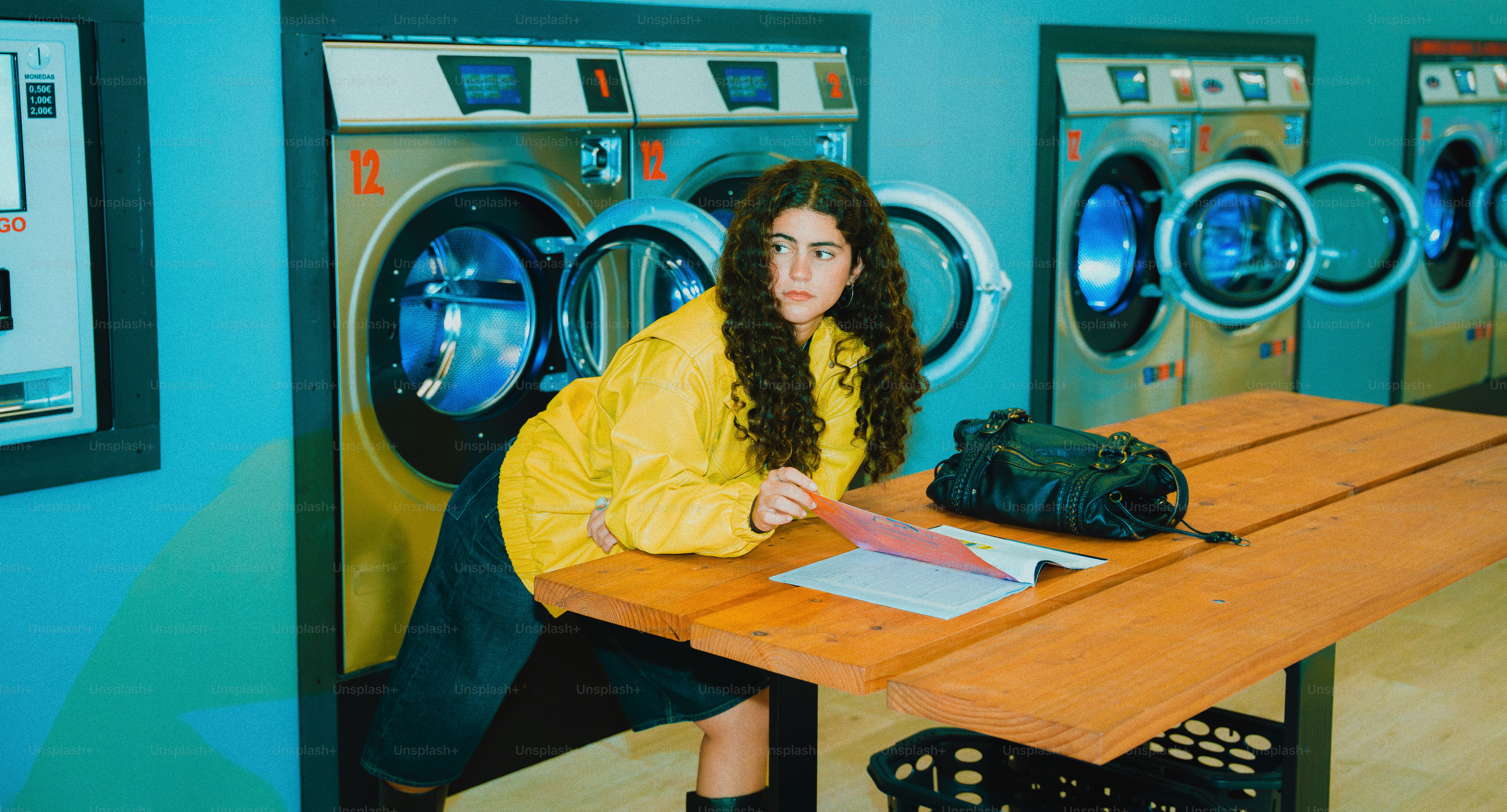 Woman in yellow jacket at laundromat with washing machines photo ...