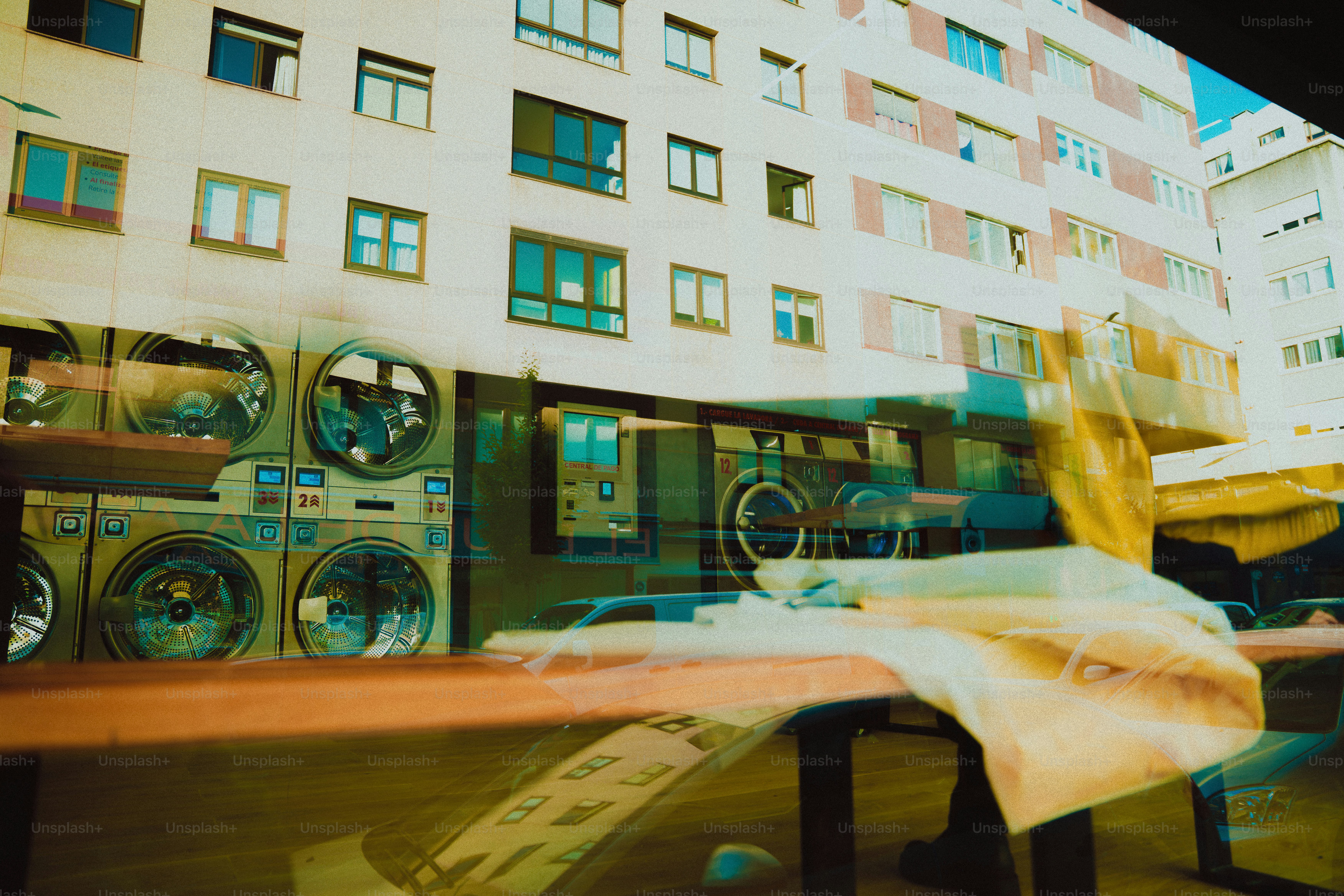 Reflet des machines à laver et de la construction dans la fenêtre.