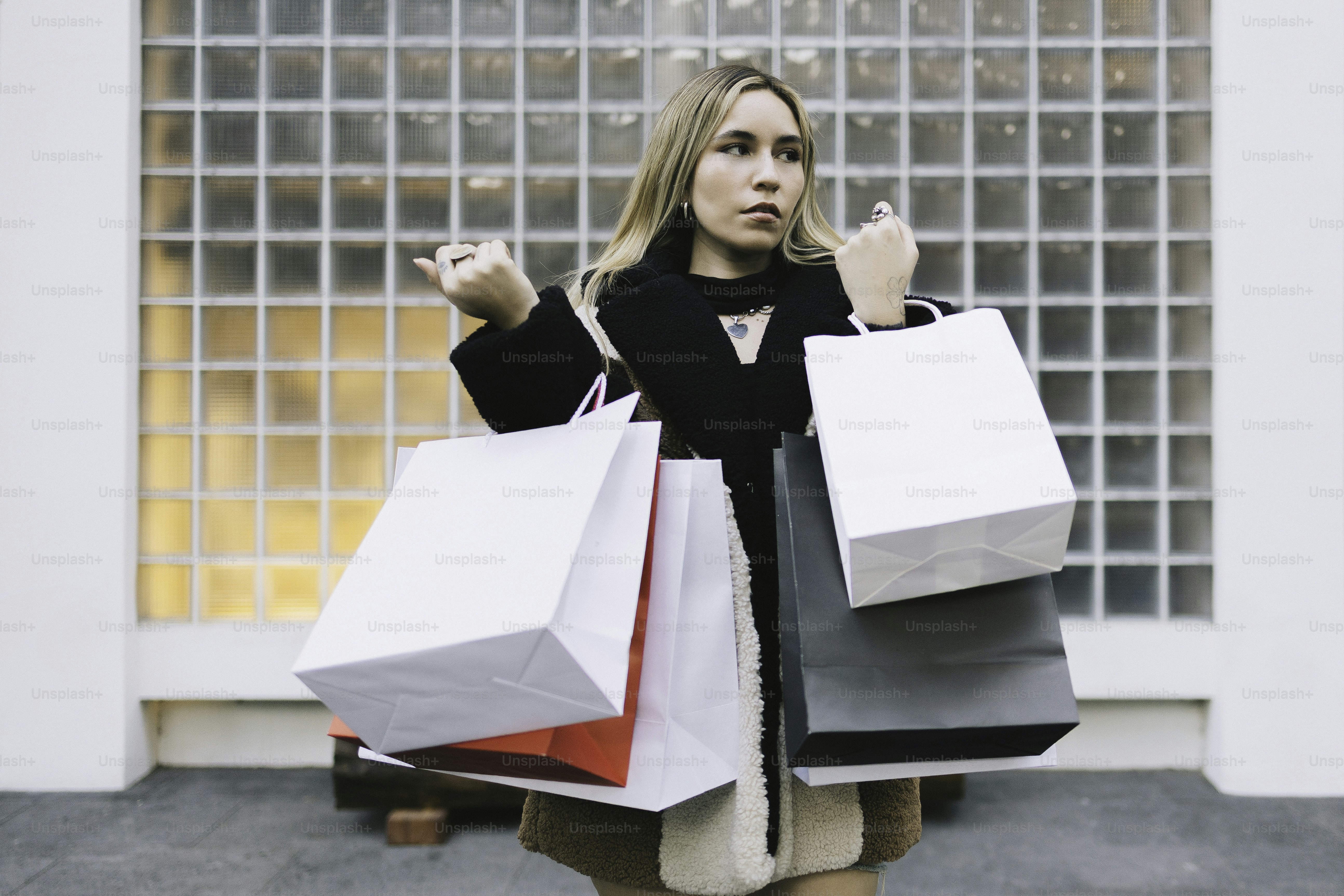 Woman holding many shopping bags outdoors