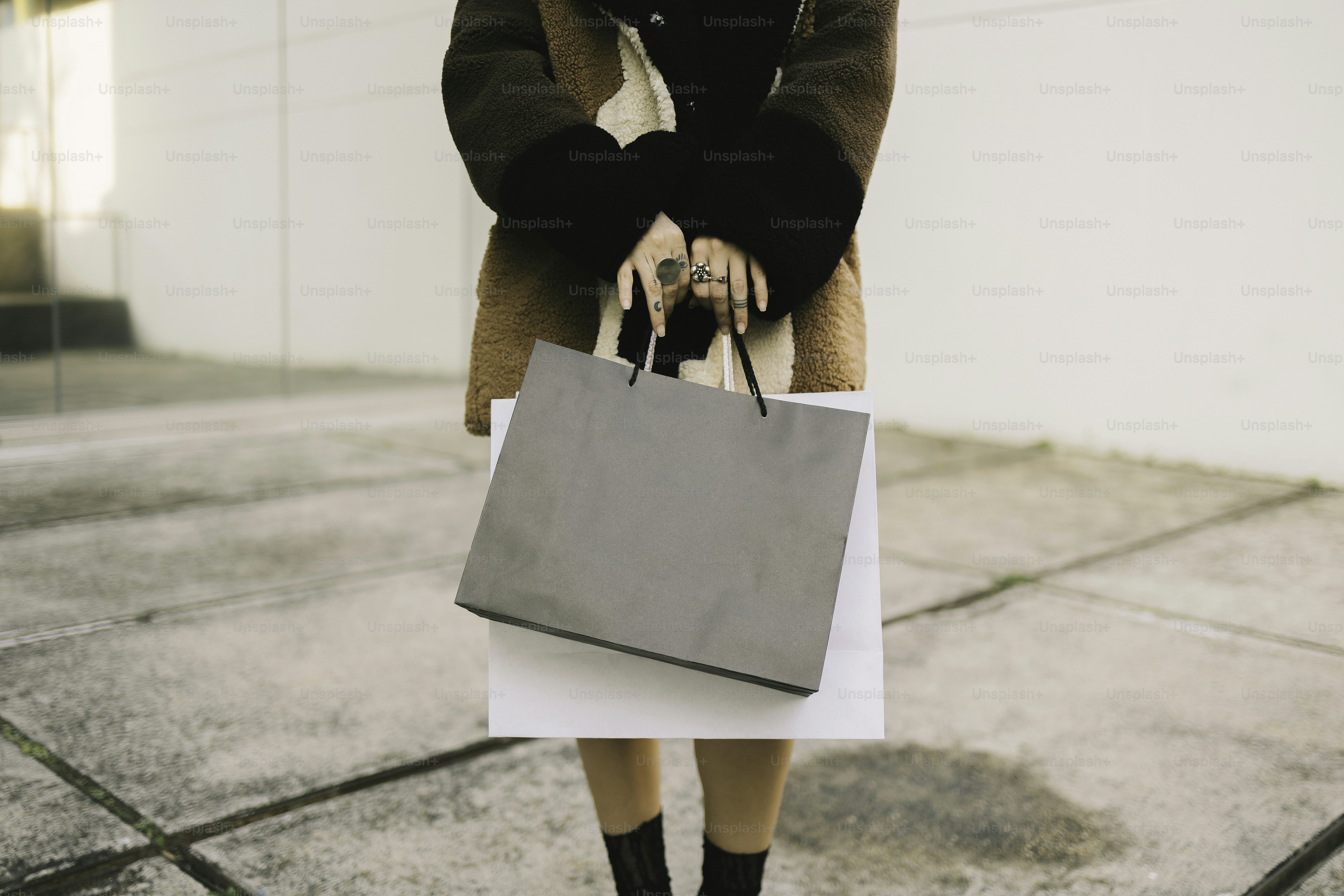 Woman holding shopping bags in front of a building photo – Shopping ...