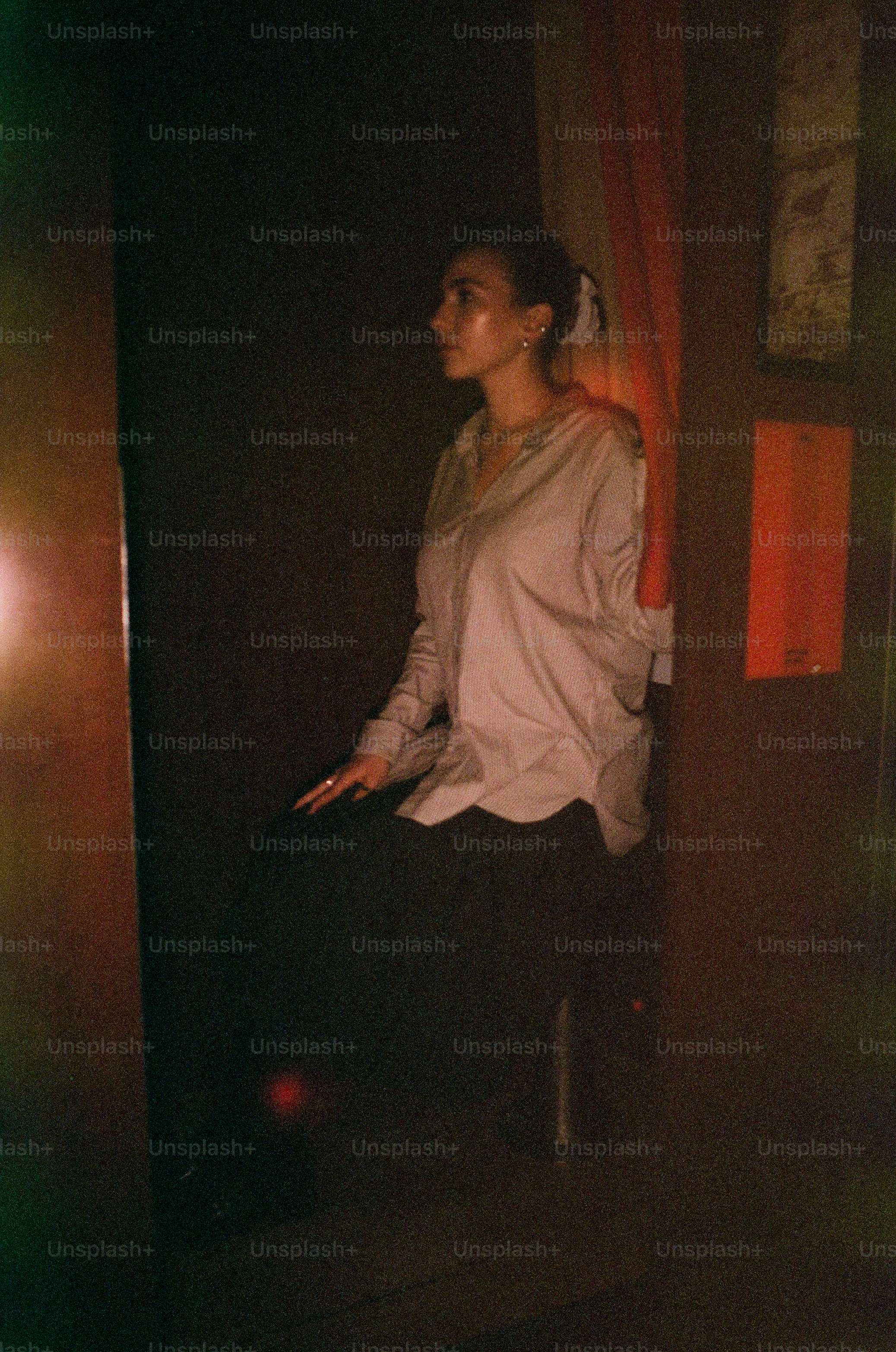 Woman in light shirt and dark skirt sitting.