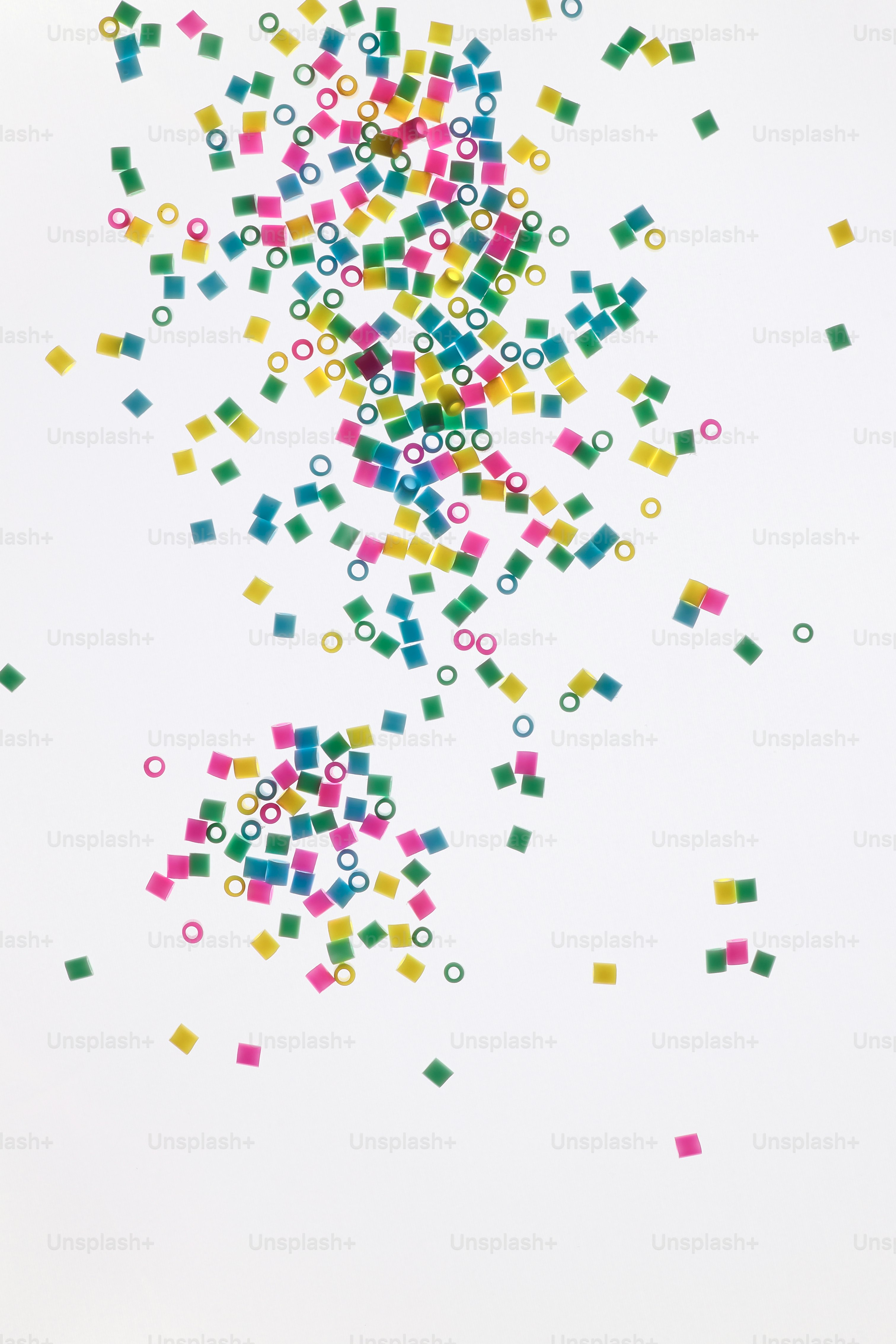 Confettis colorés dispersés et anneaux sur fond blanc