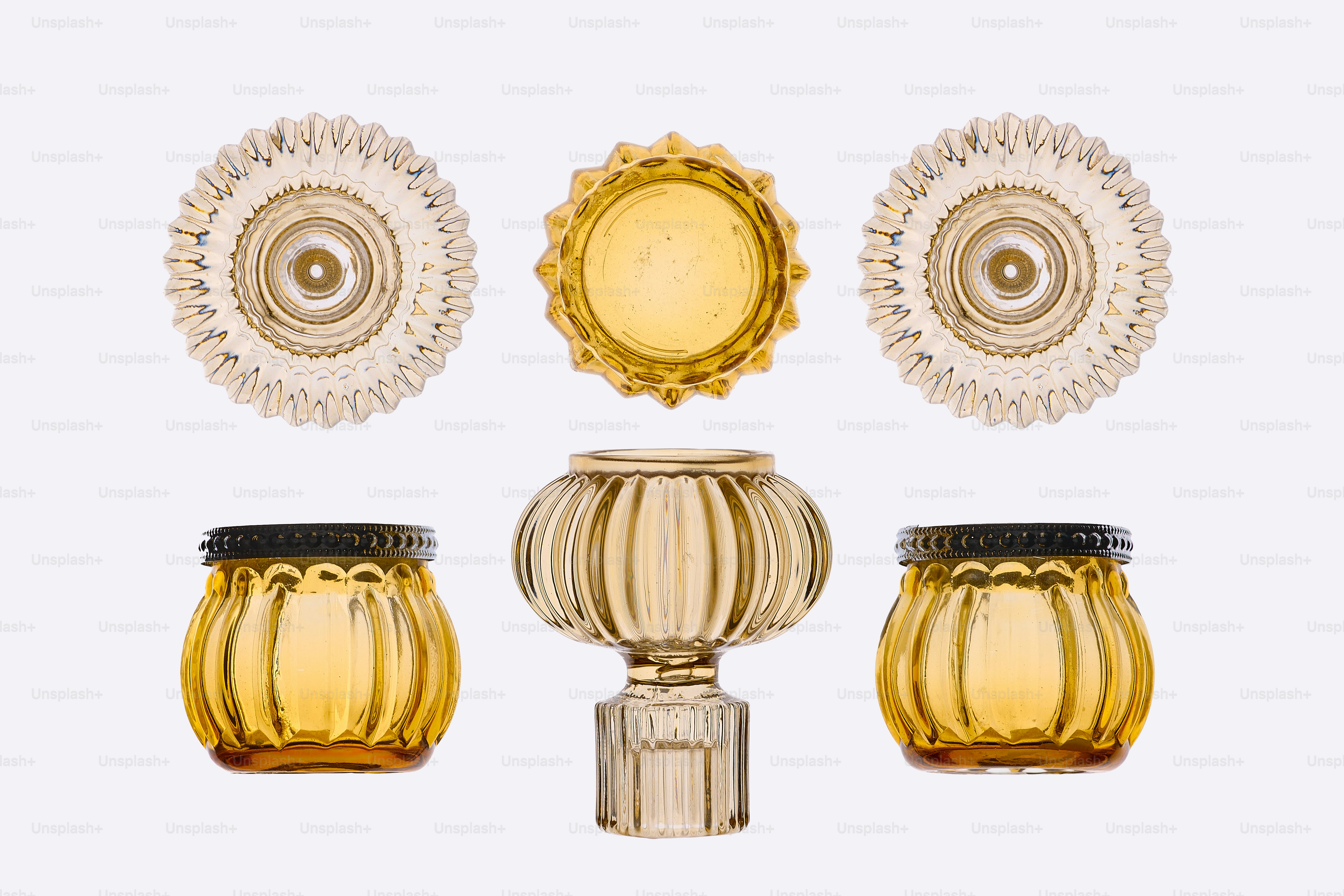 Trois bocaux en verre décoratifs et deux objets circulaires ornés.
