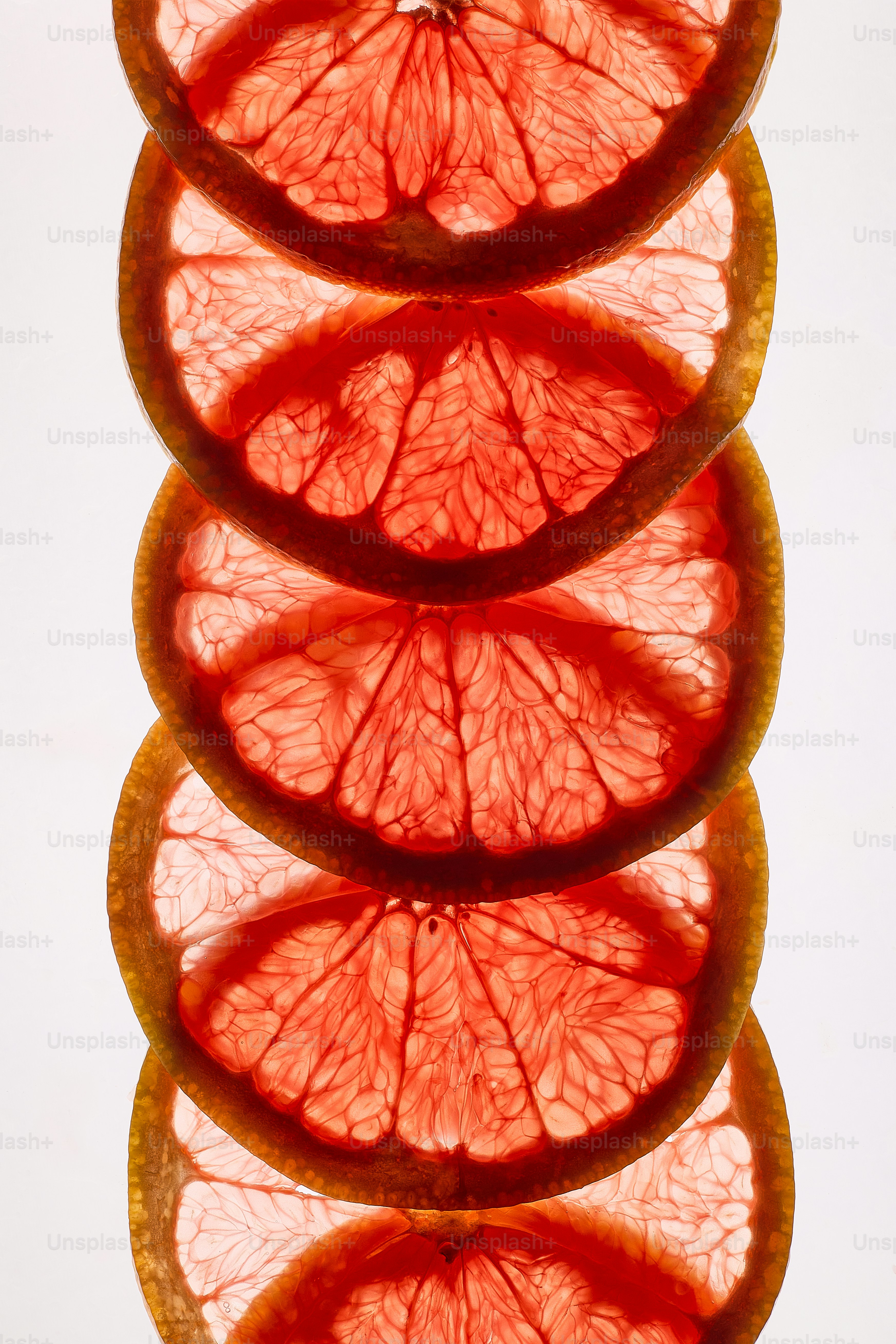 Pile de tranches de pamplemousse translucides sur blanc