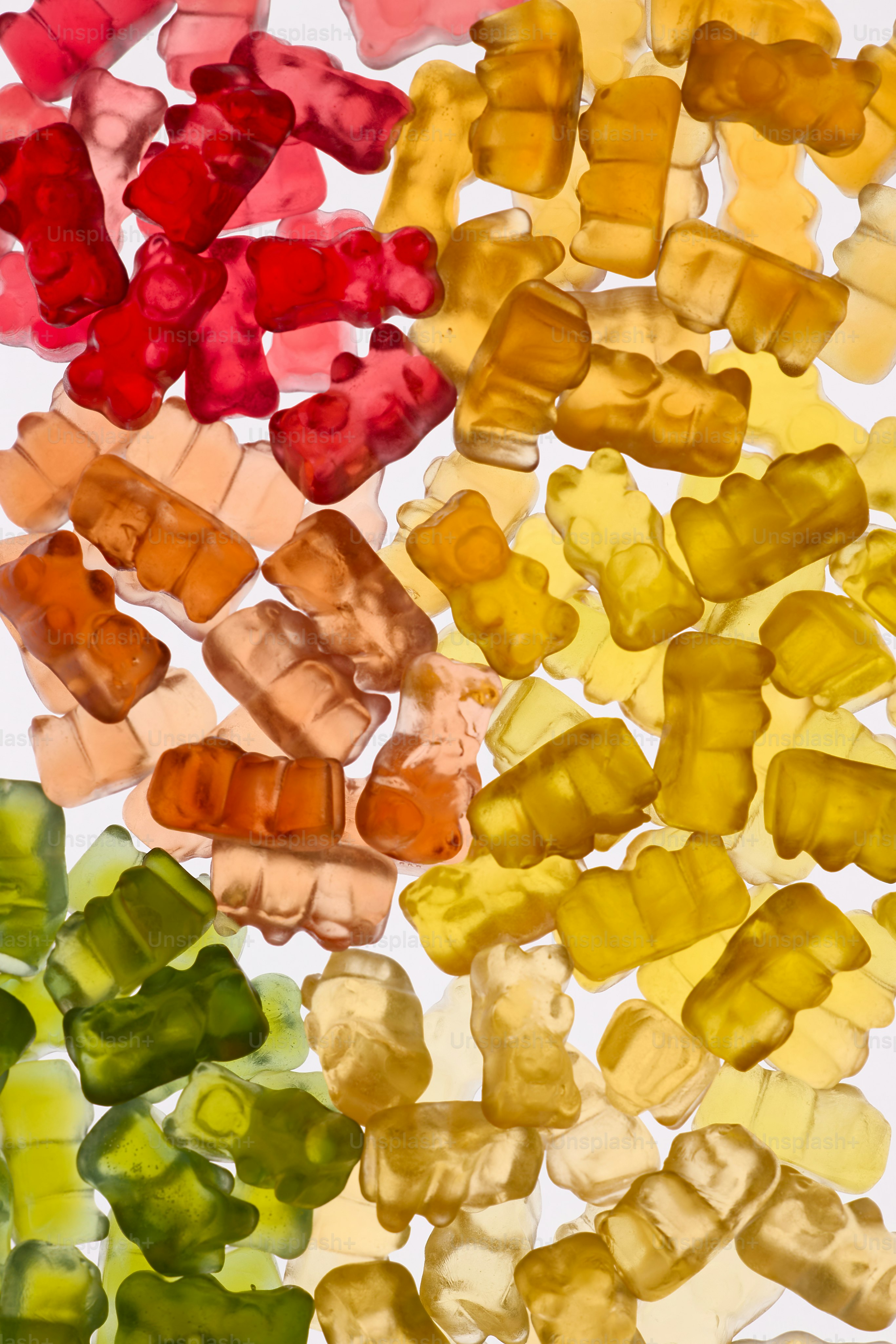 Oursons en gélatine colorés disposés dans un dégradé arc-en-ciel.