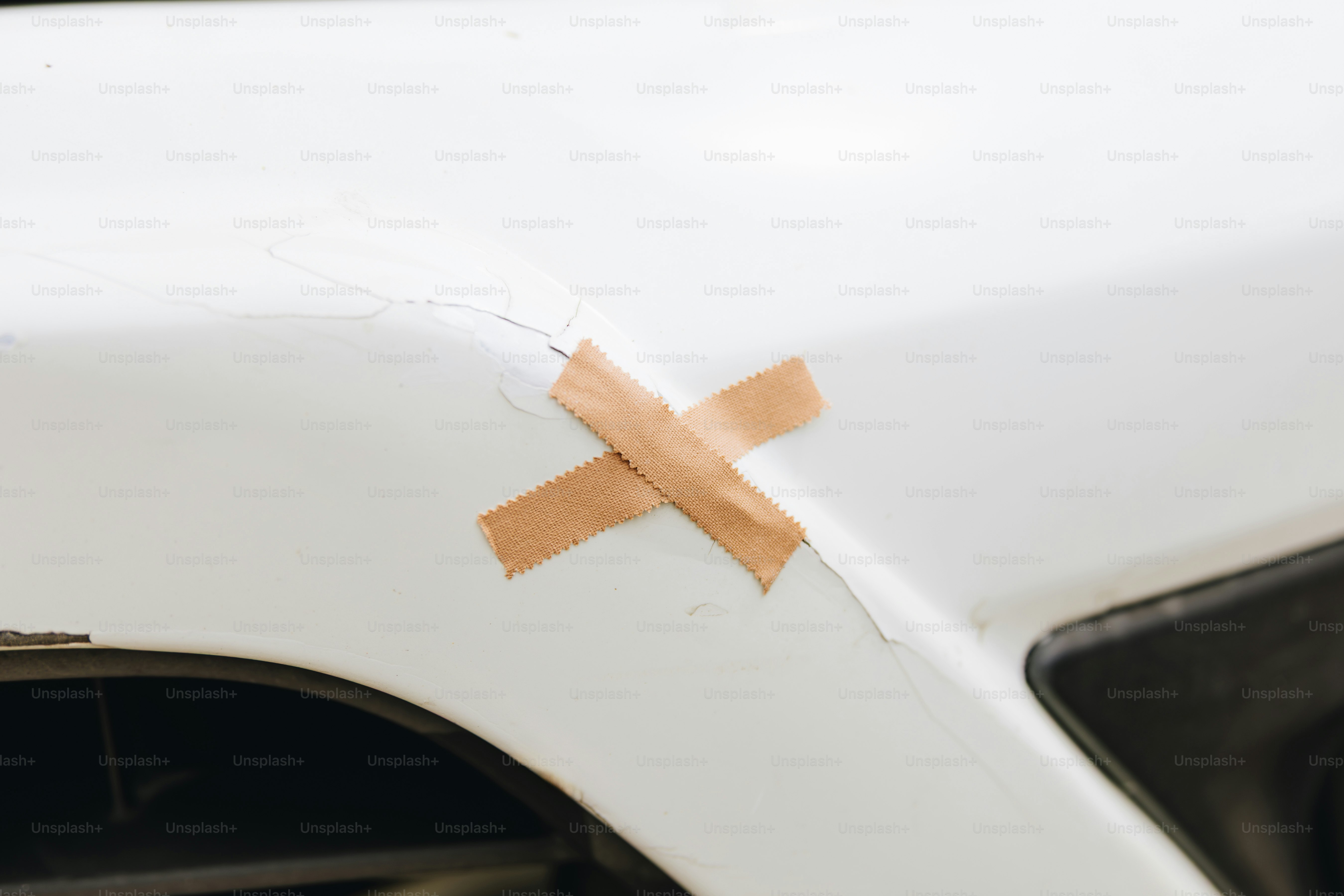 Pflaster auf weißer Autooberfläche