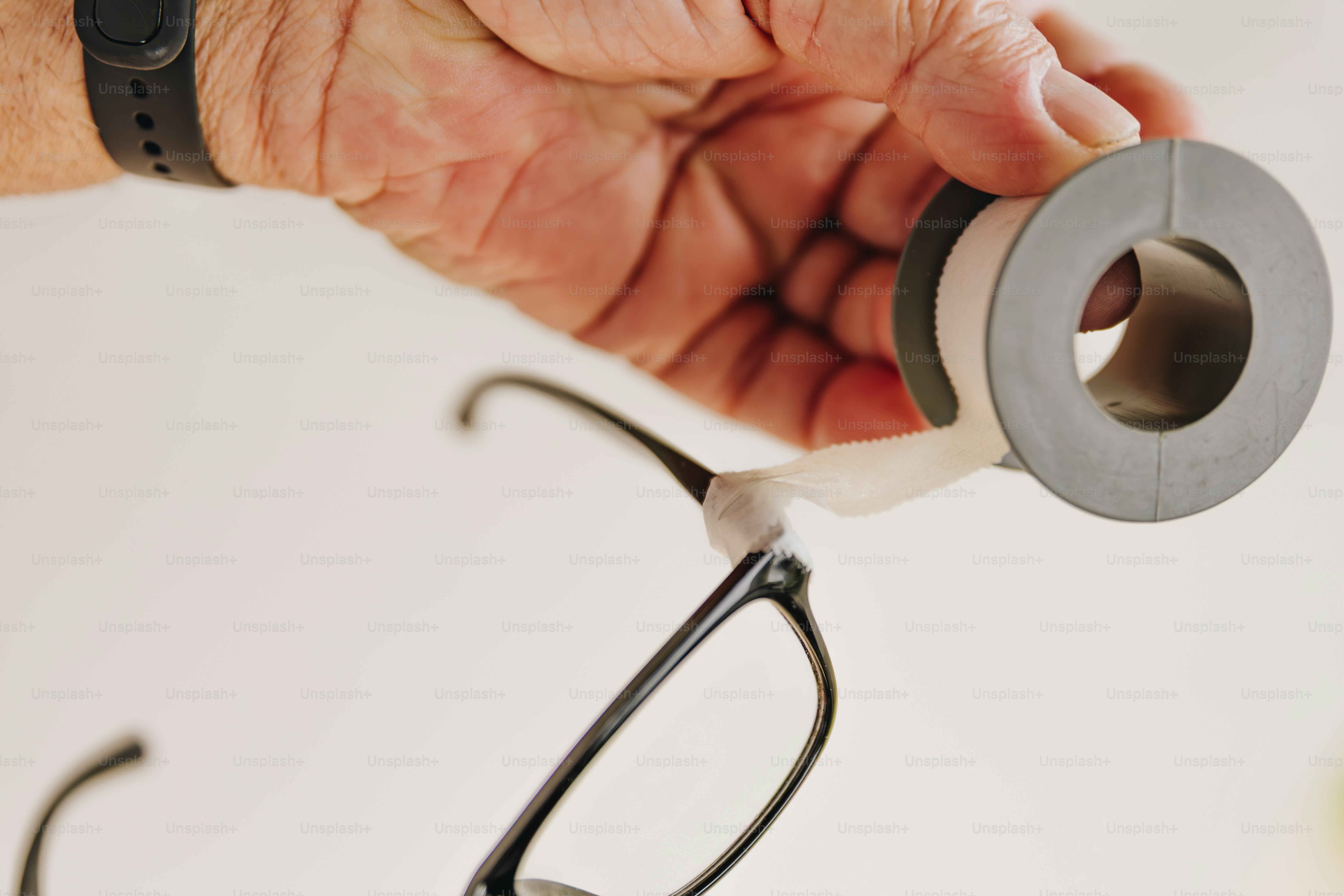 Handkleben von Klebeband auf Brille