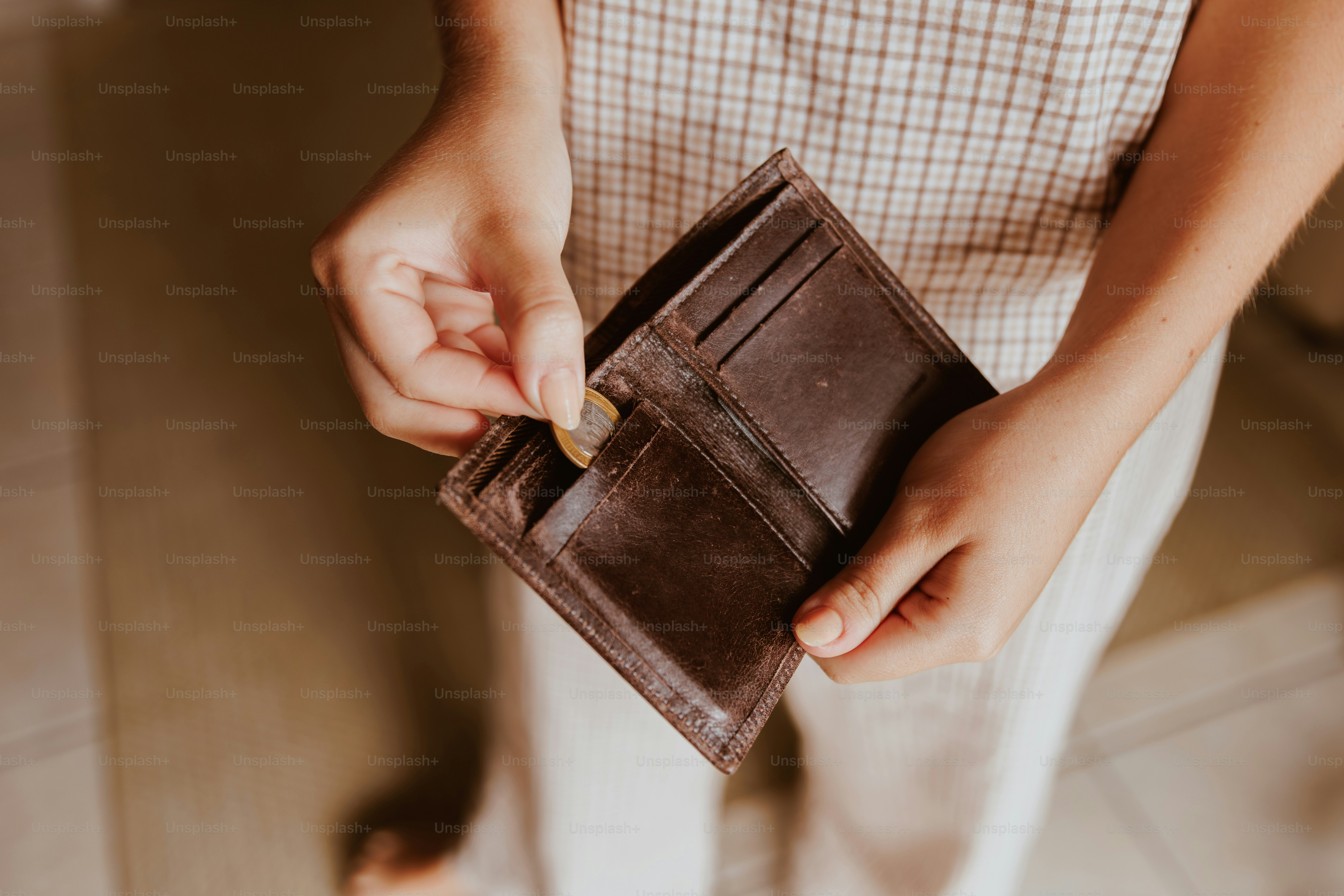 Person, die Münze in eine leere Brieftasche steckt