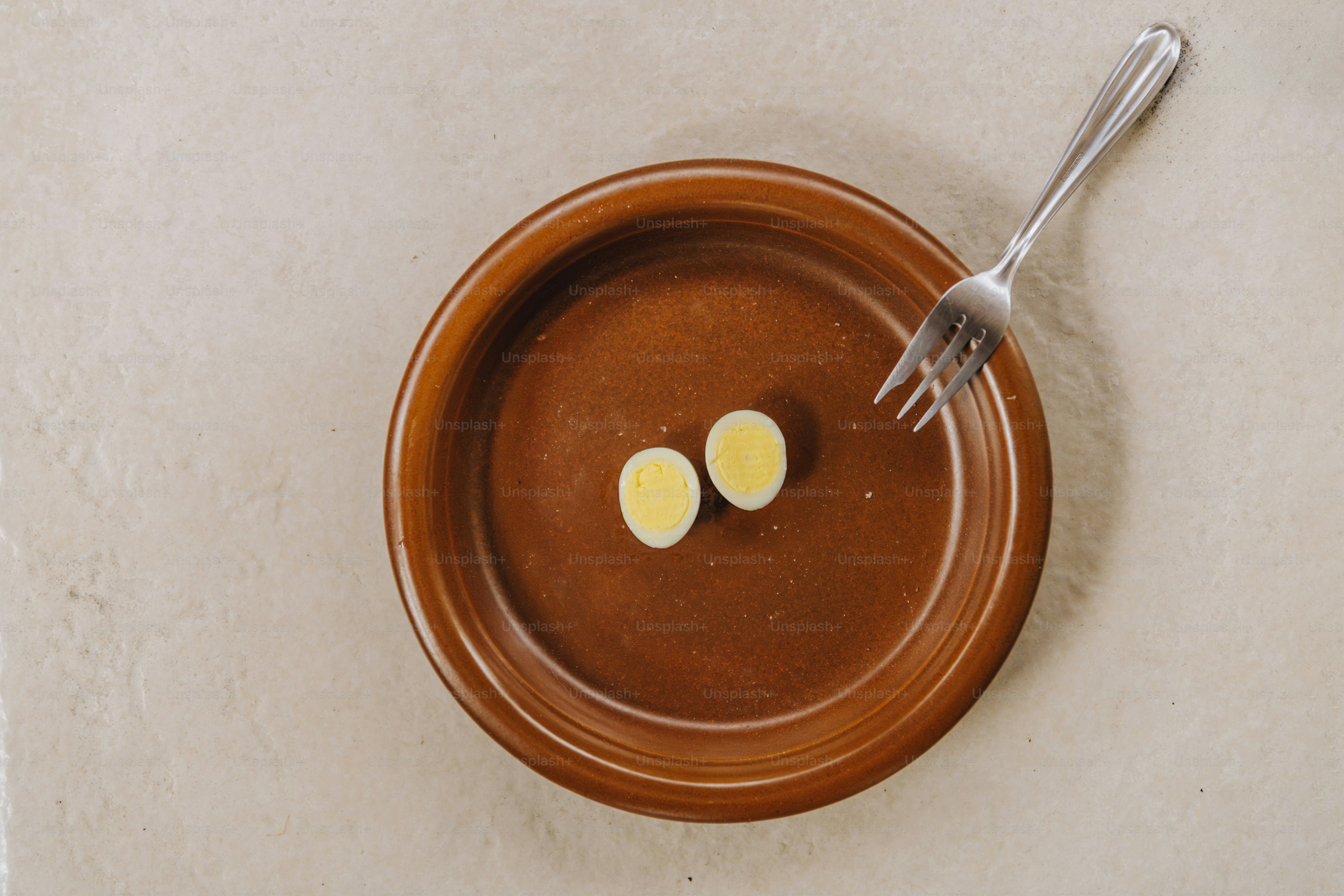 Deux moitiés d’un œuf de caille dur sur une assiette.