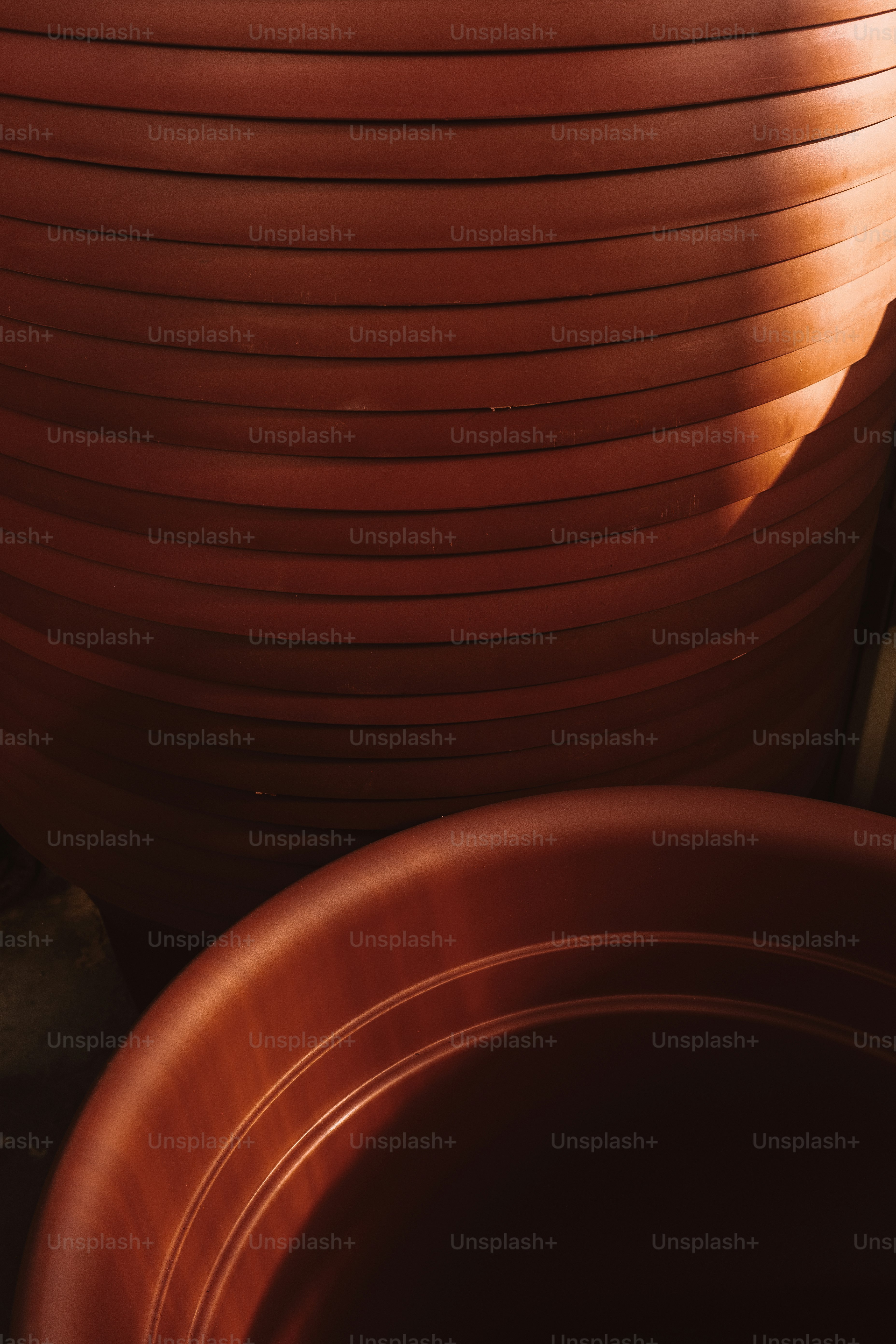Potes de terracota empilhados com sombras de projeção de luz solar