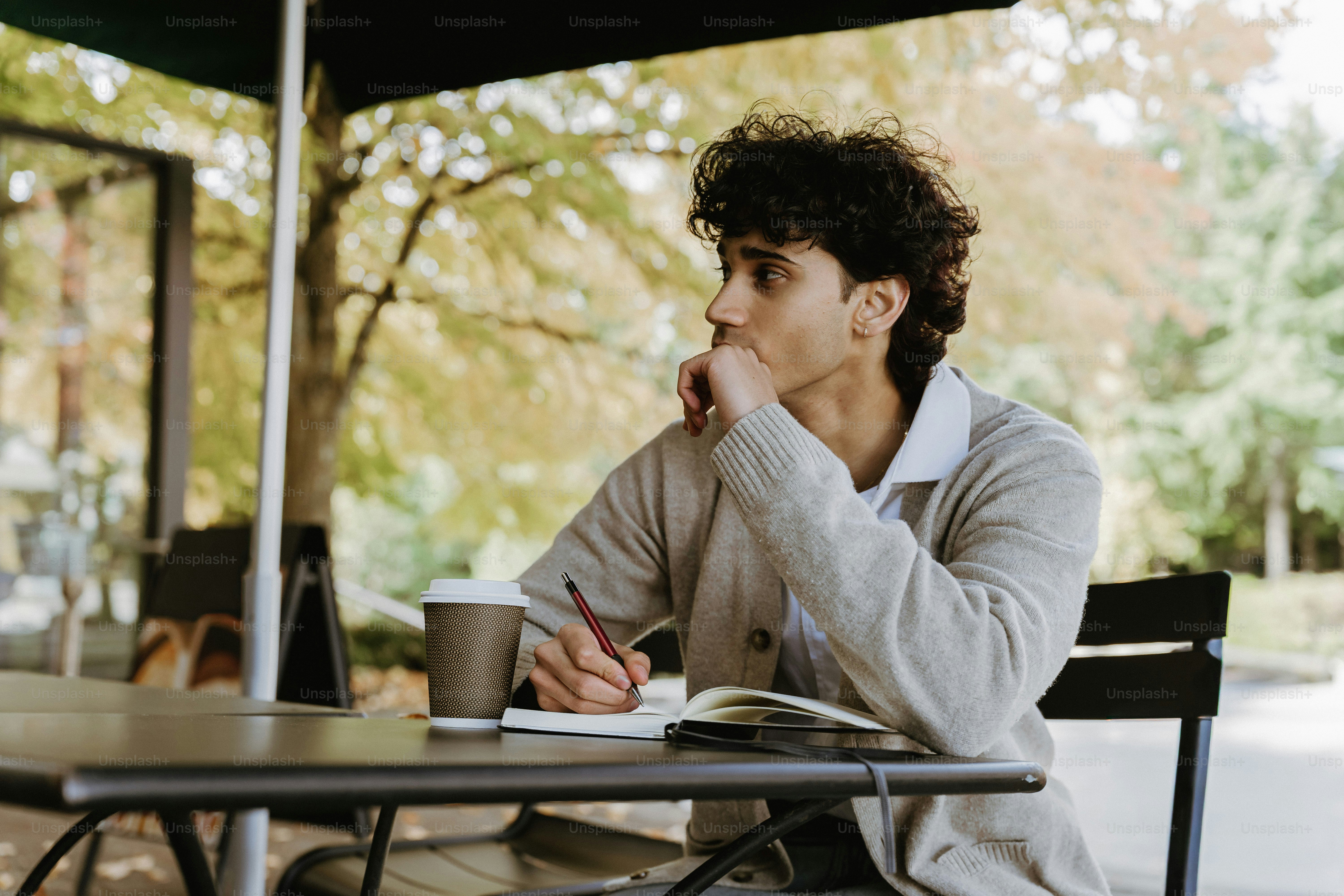 Man sitting at table with coffee and notebook