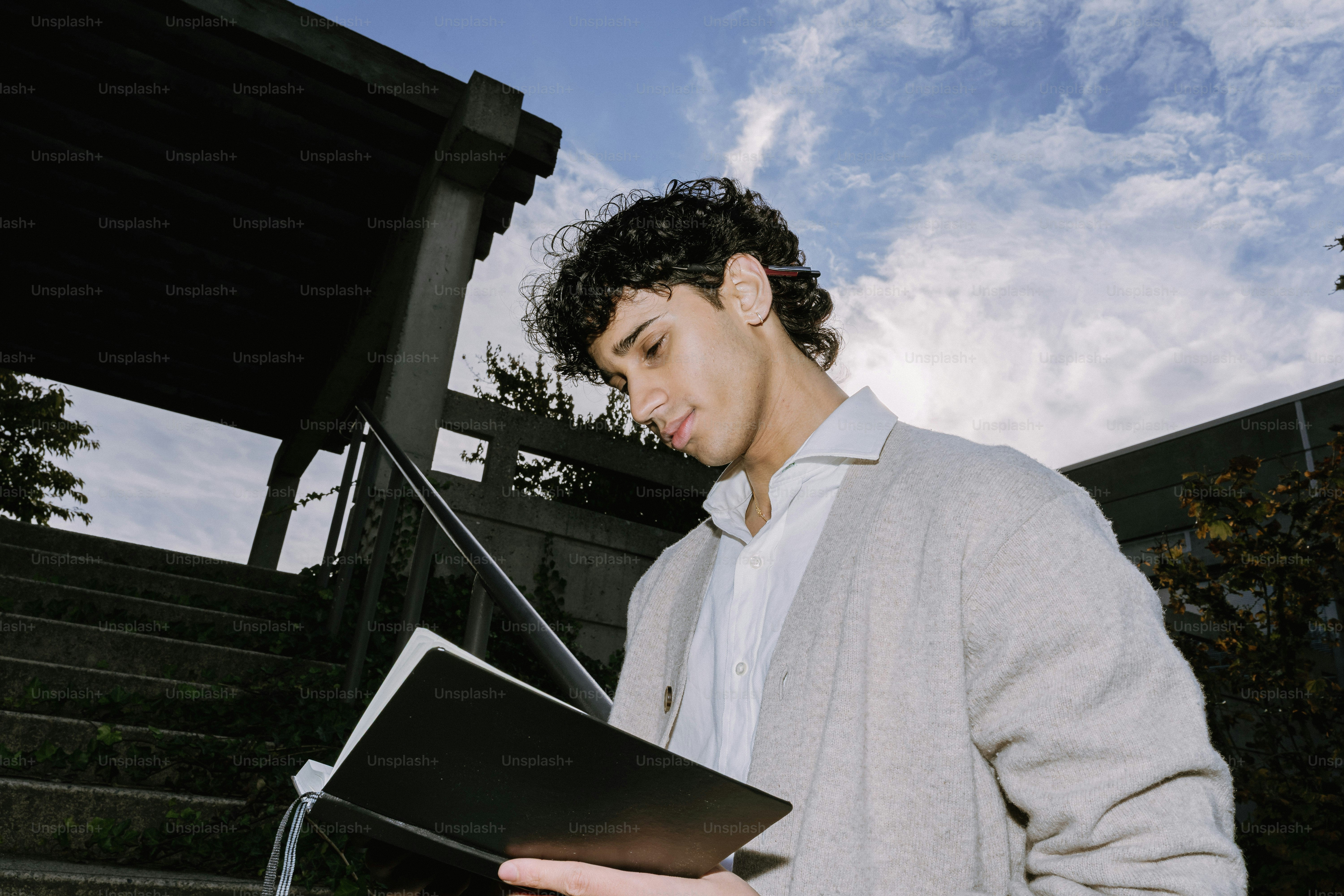 Young man reading a book on outdoor stairs
