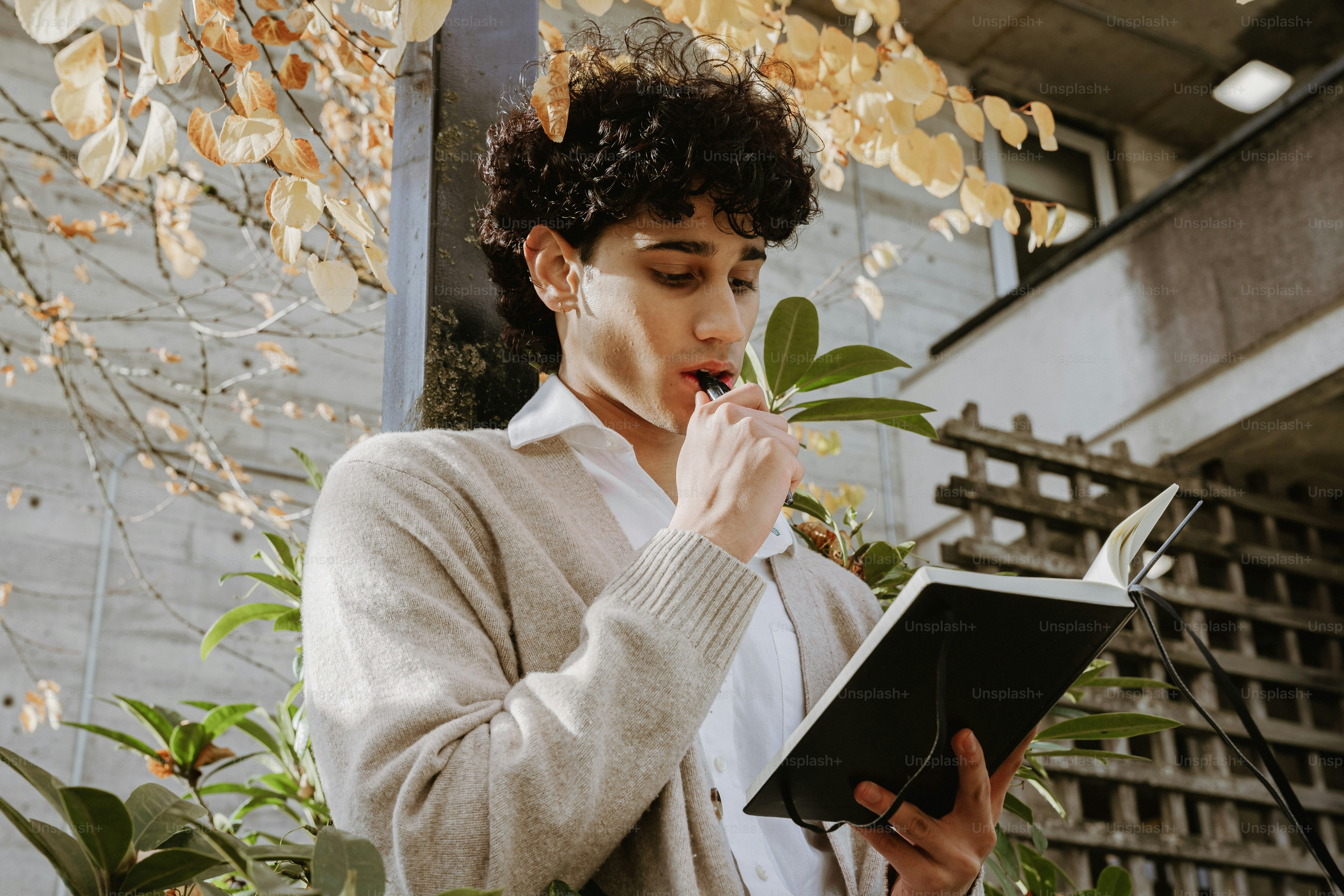 Young man writing in a journal outdoors