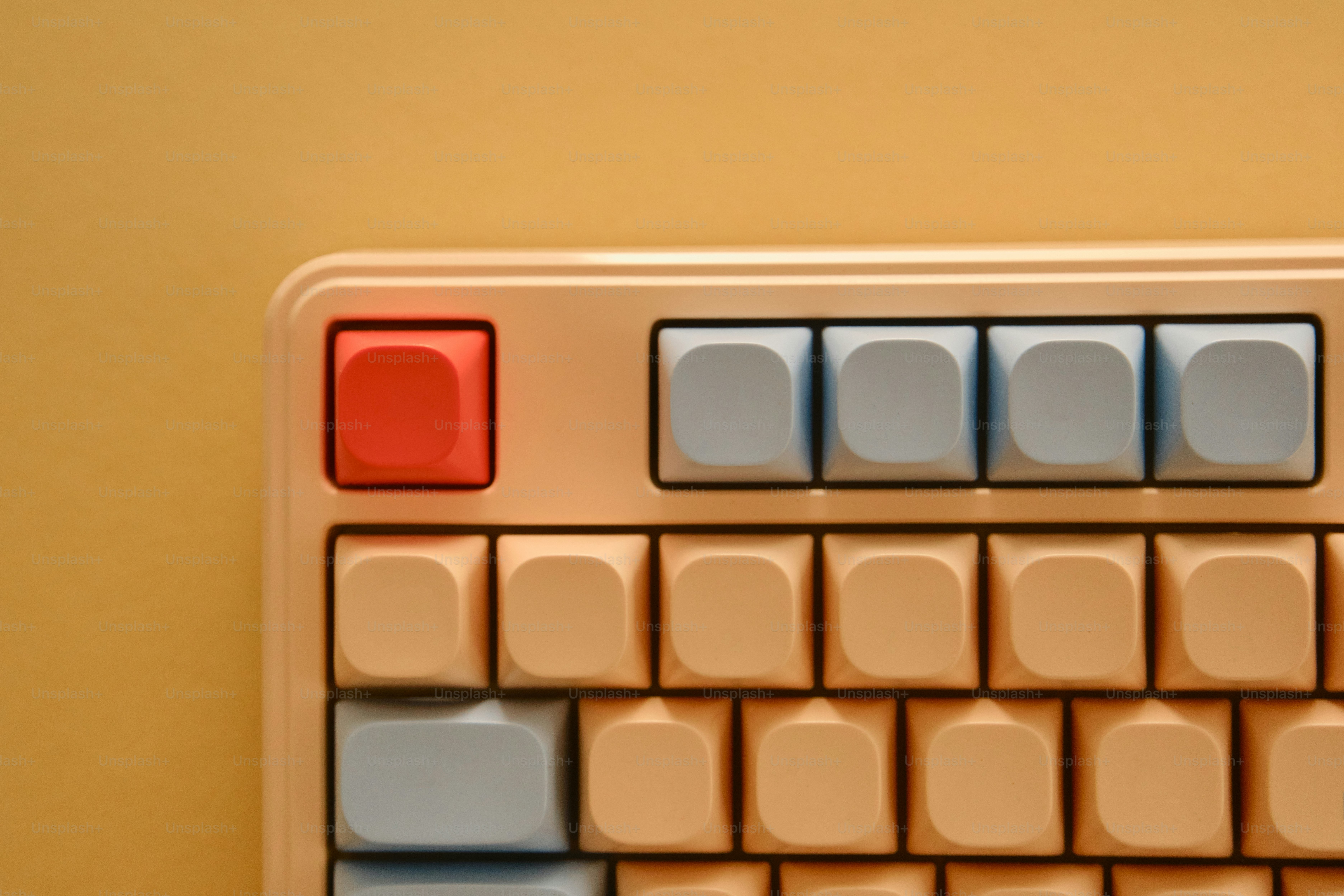 Close-up of a pastel keyboard with a red key.