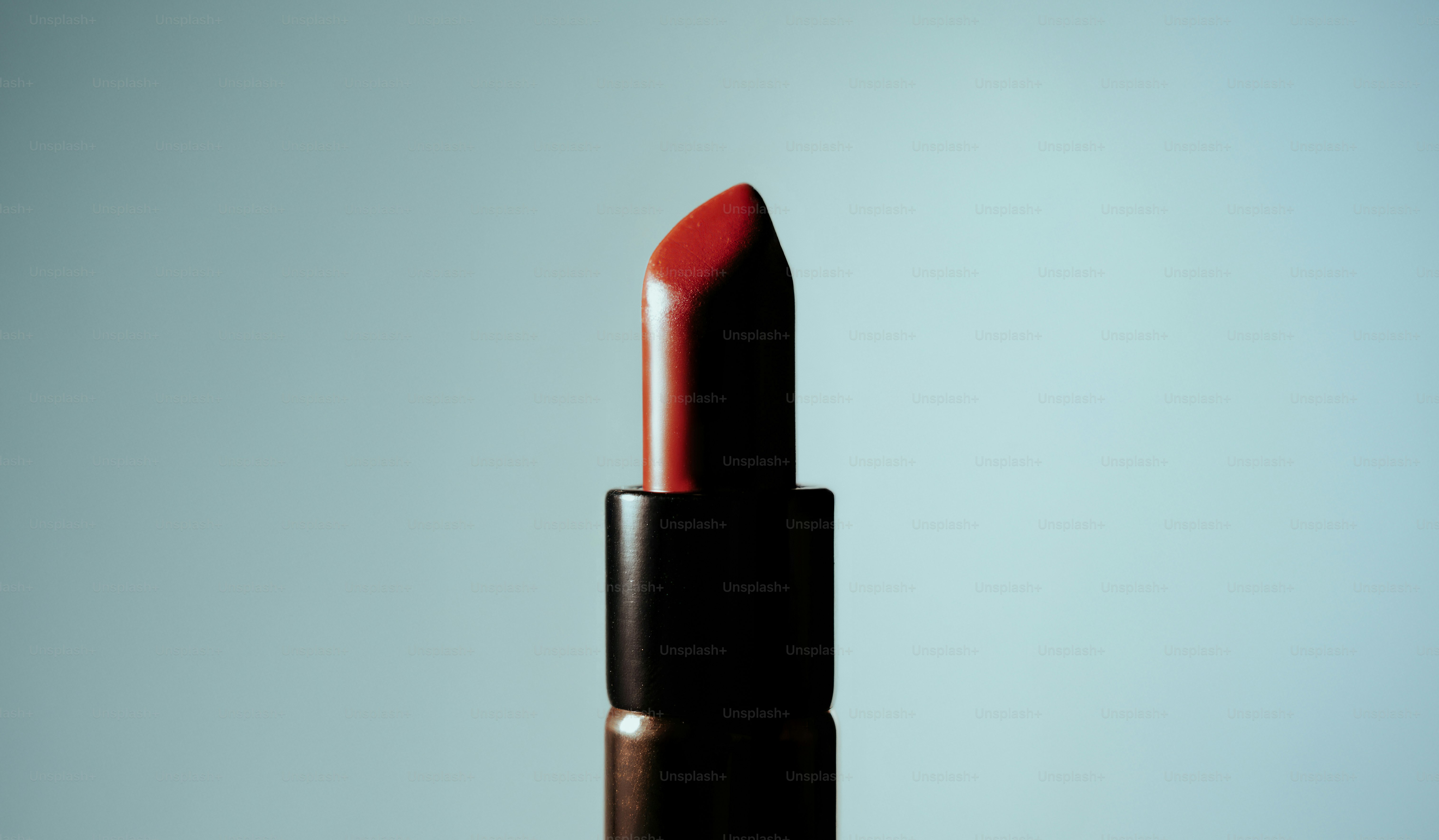 A red lipstick against a light blue background
