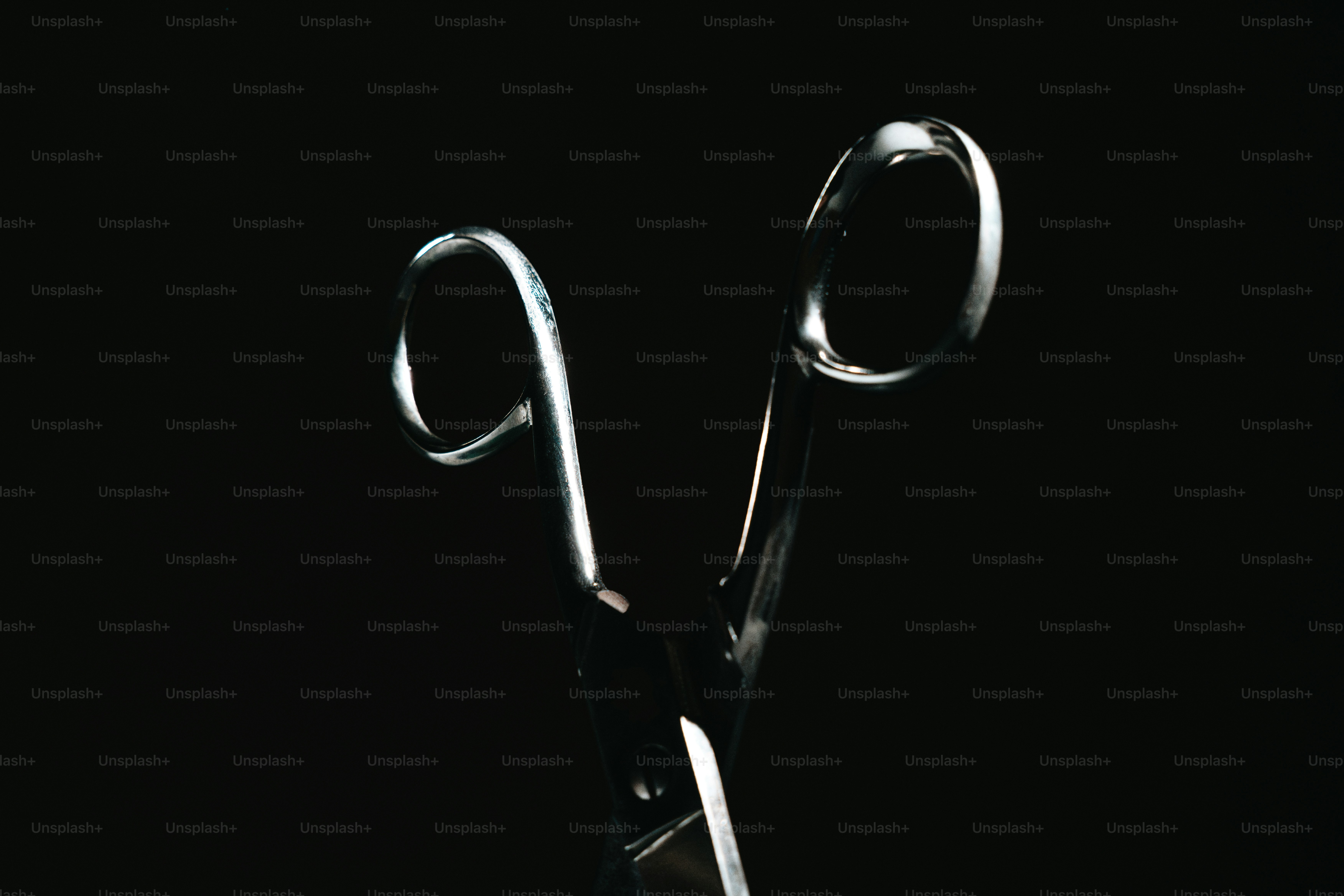 Shiny metal scissors on a black background