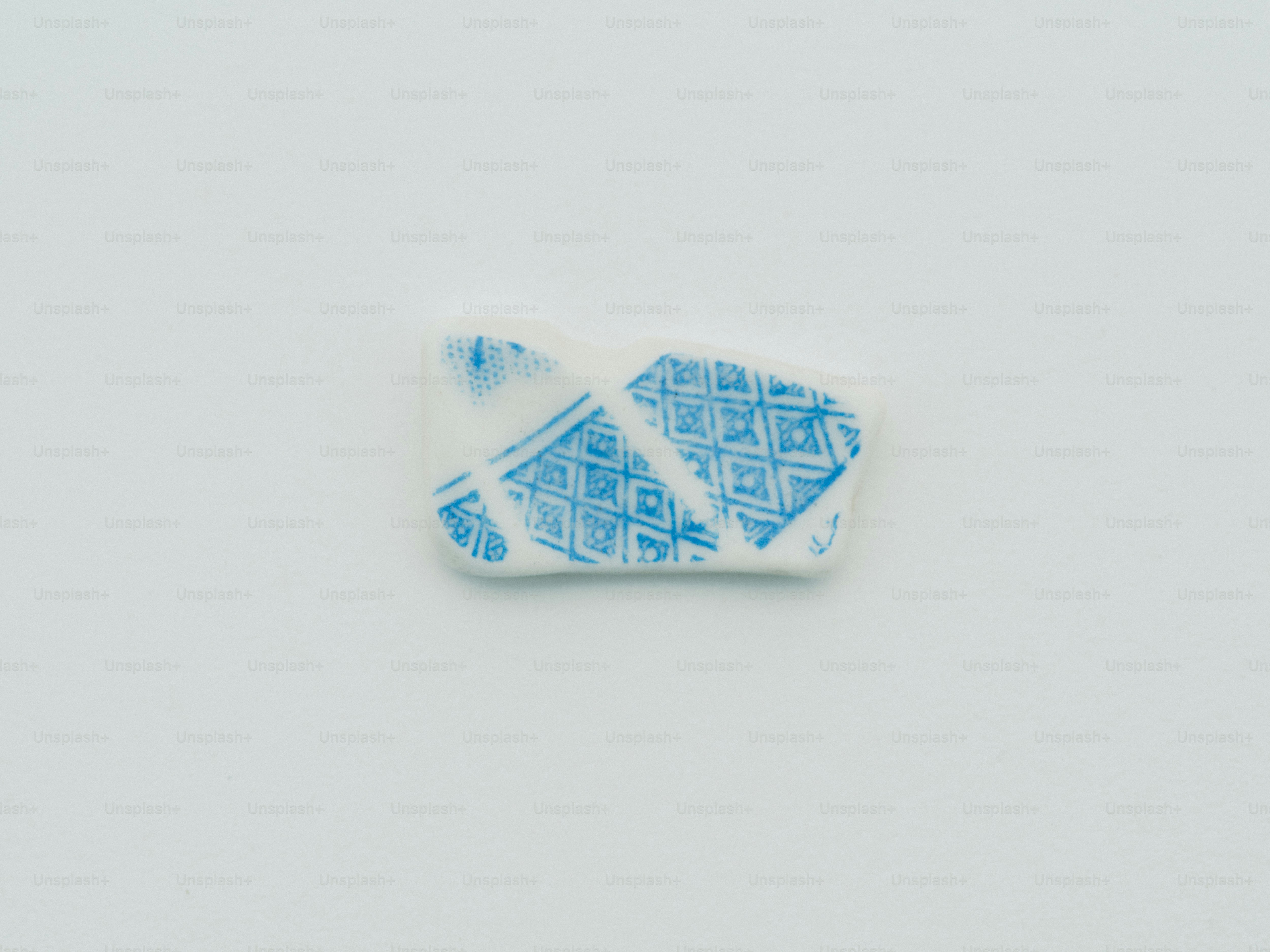A small white ceramic shard with blue floral design. photo – Pottery ...