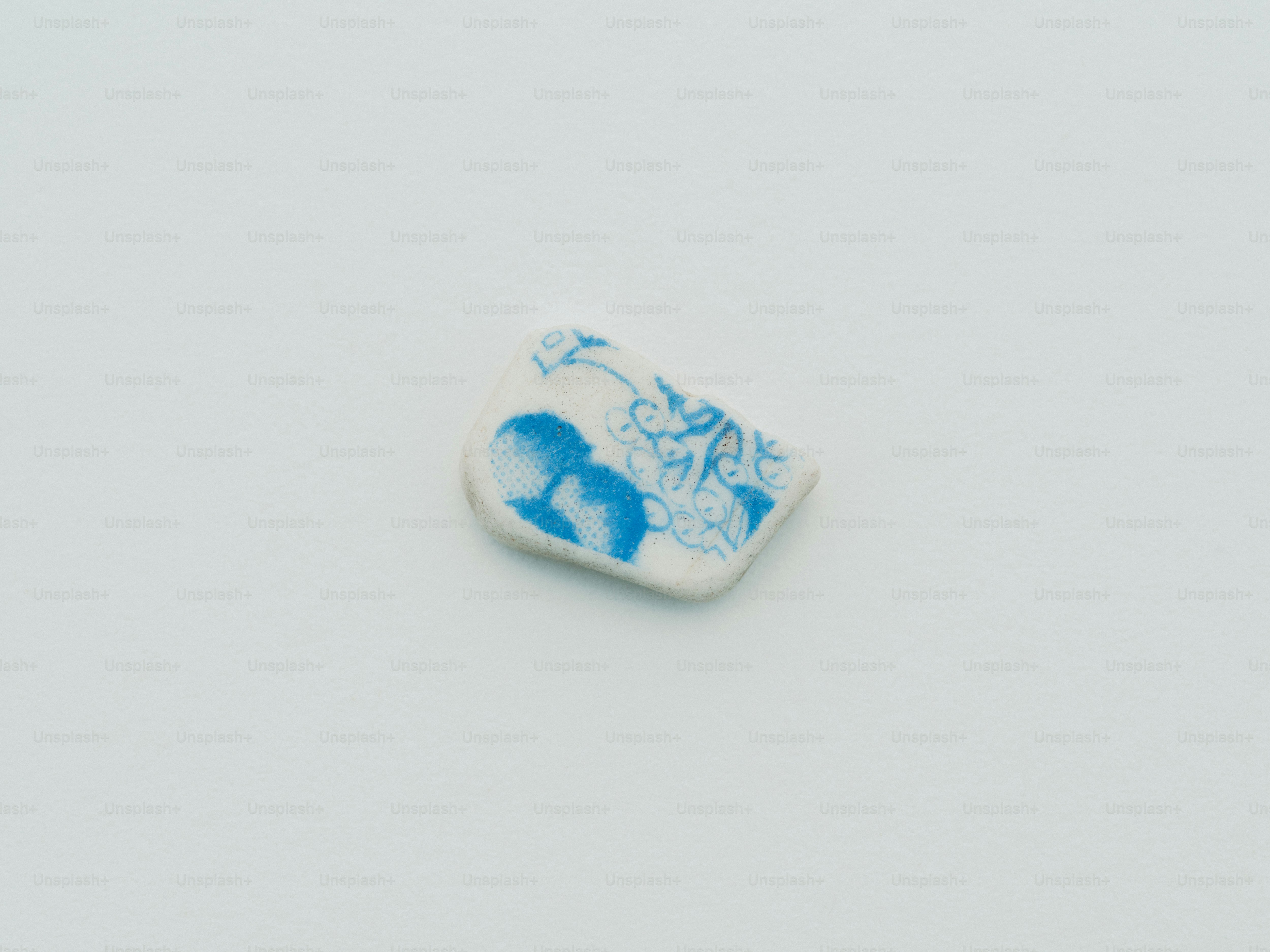 A small white ceramic shard with blue floral design. photo – Pottery ...
