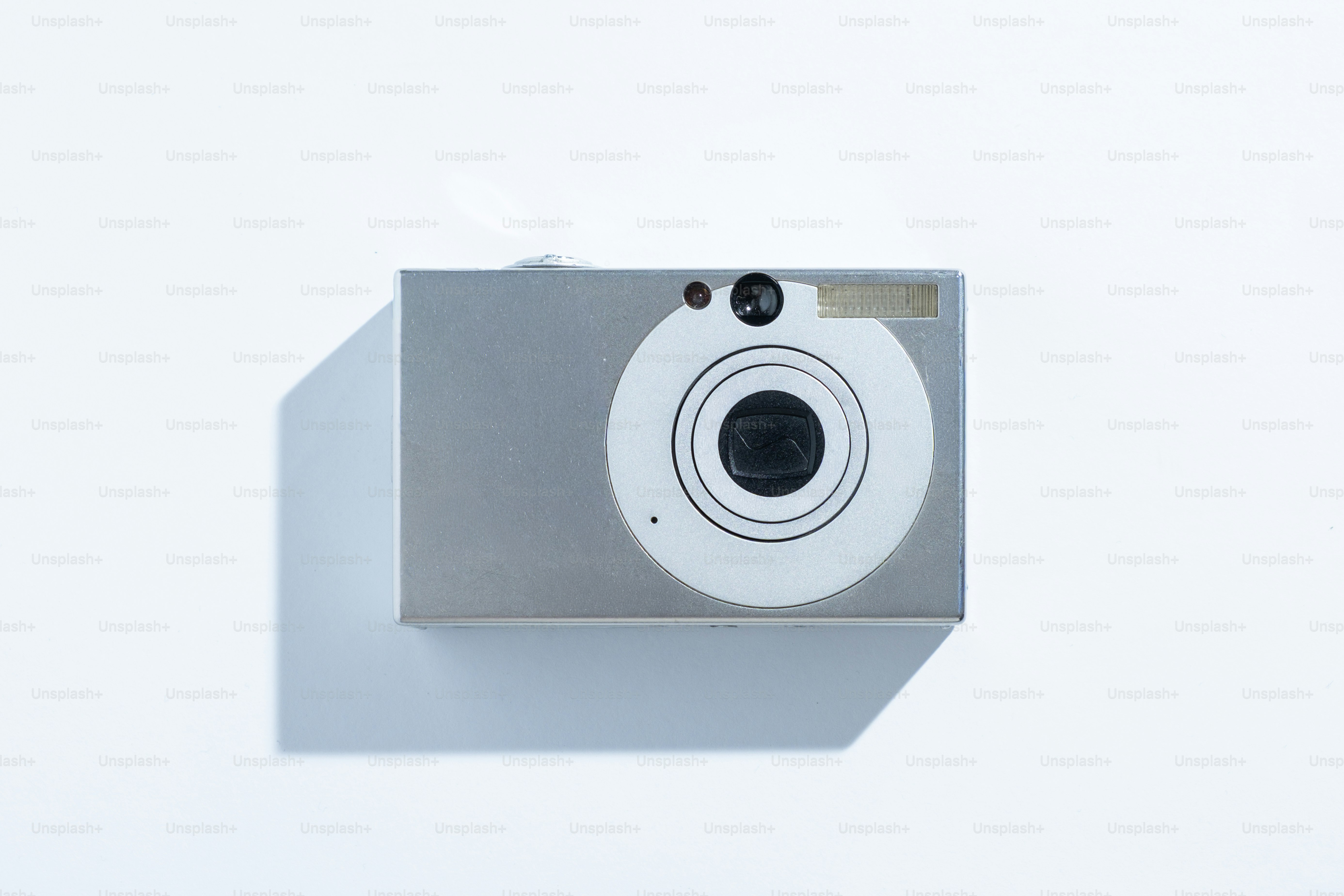 A silver digital camera on a white background.