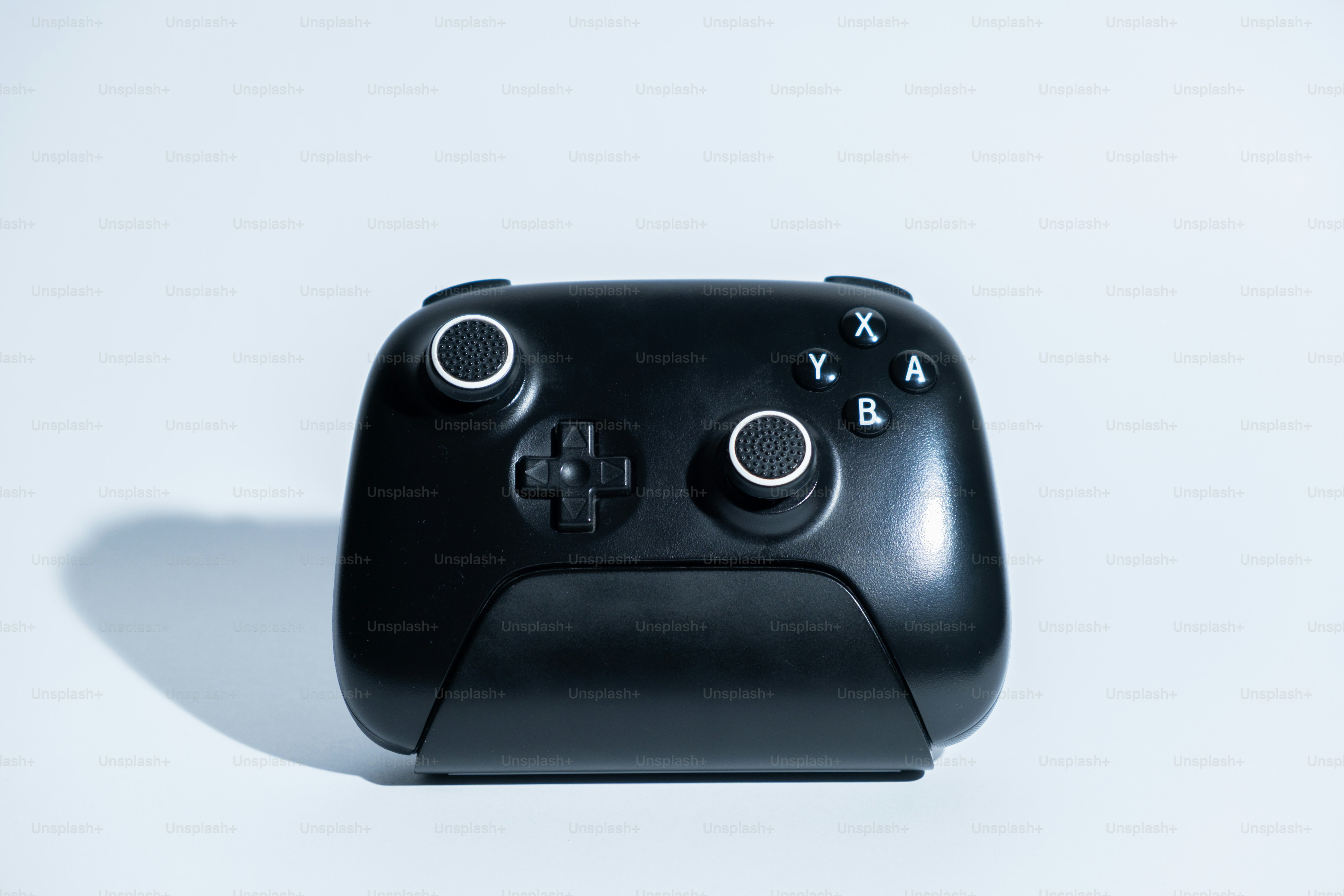 Une manette de jeu vidéo noire sur fond blanc.